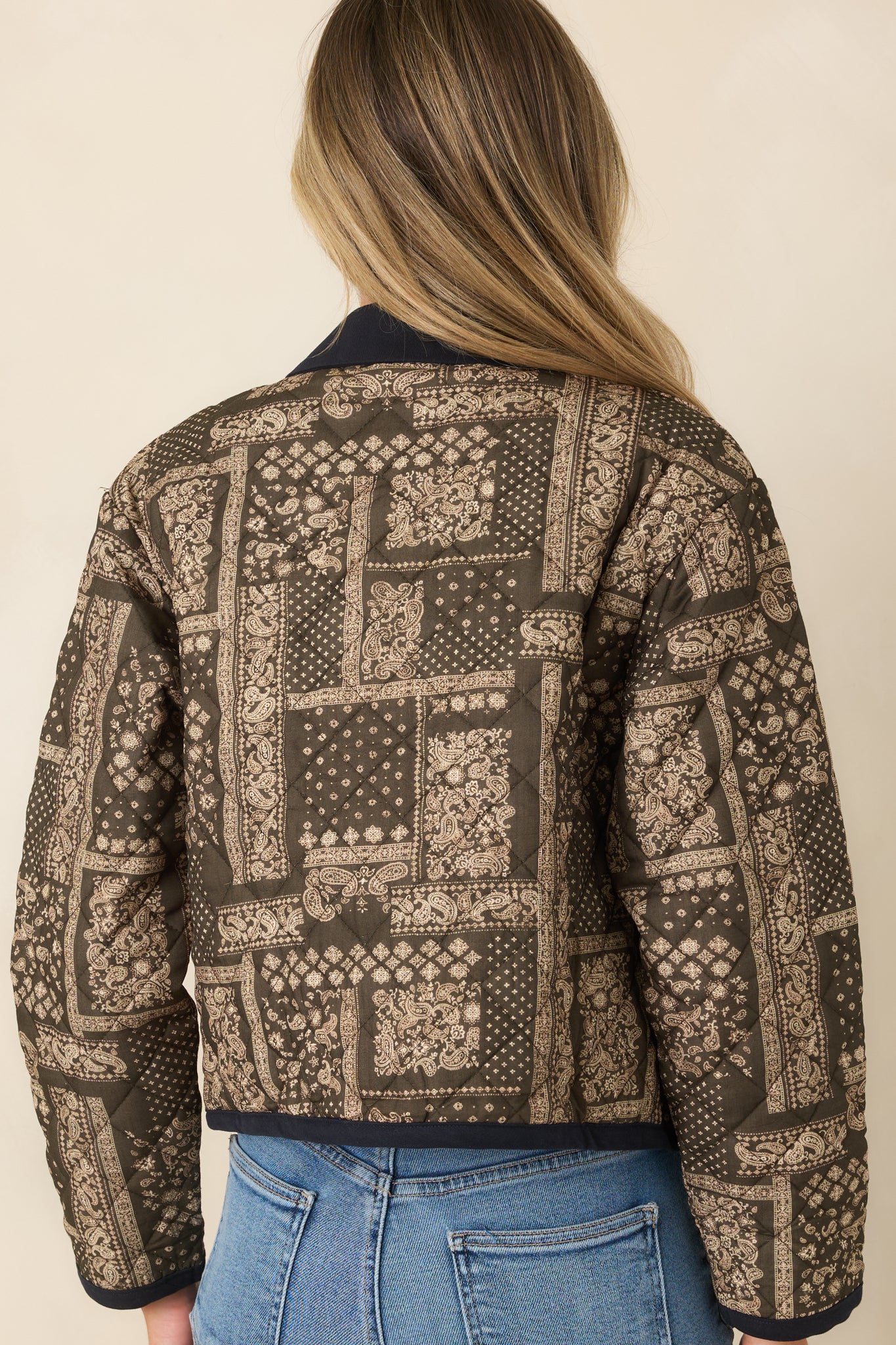 Rear view of the cropped jacket showcasing the green and ivory paisley patchwork print, long sleeves, and clean back silhouette.