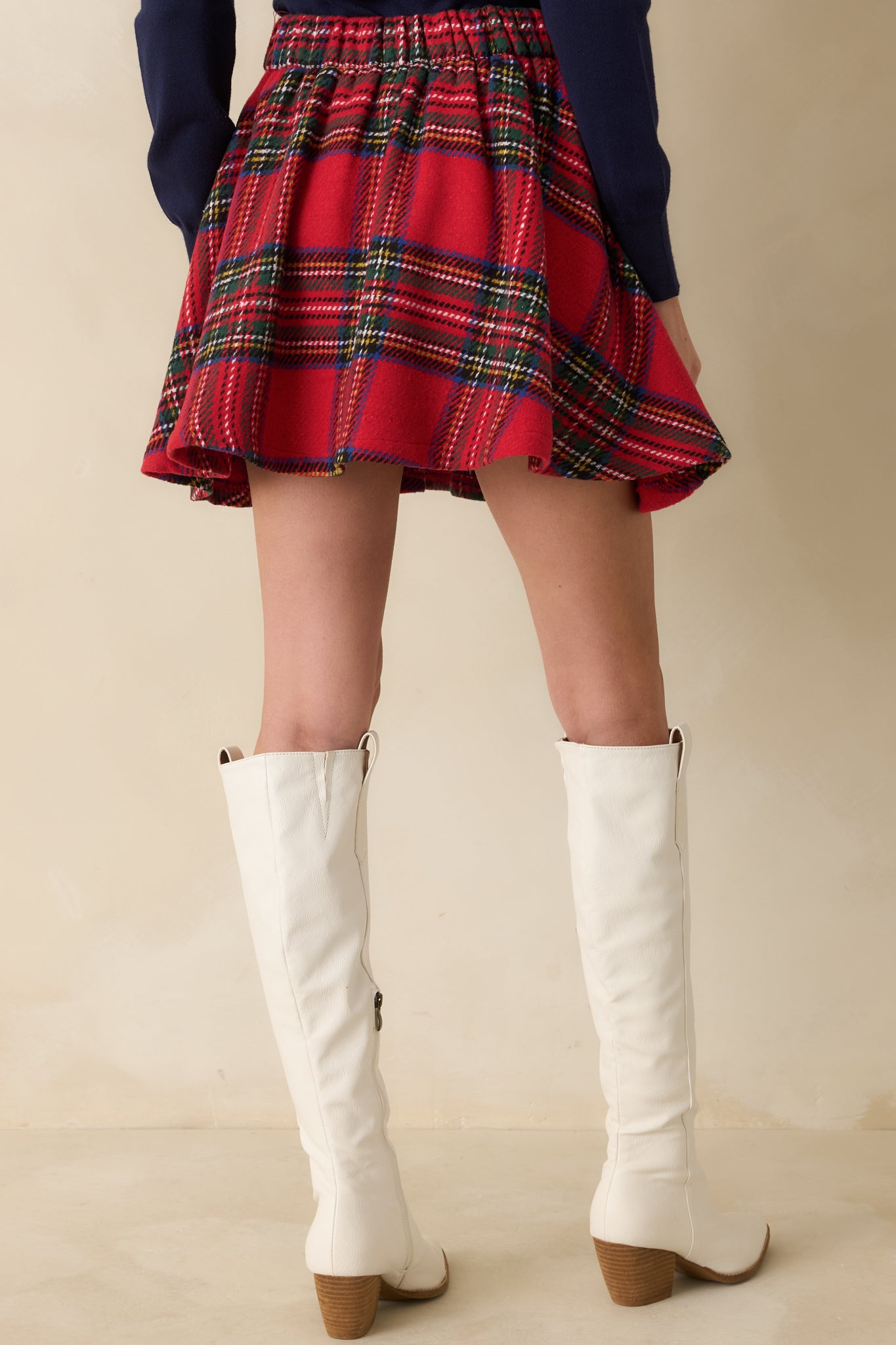 Rear view of plaid mini skirt displaying invisible back zipper and flared A-line silhouette.