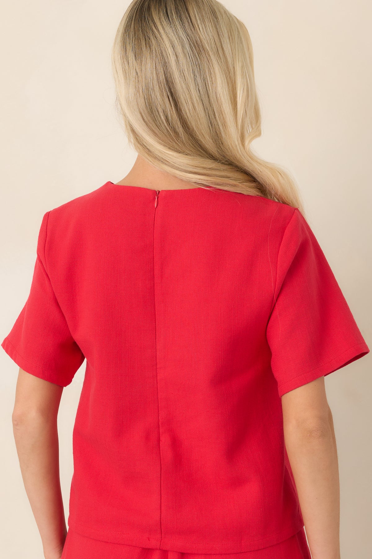 Rear view of the cotton colorblock top showcasing its relaxed silhouette, short sleeves, crew neckline, and vibrant red and blush pink panels.