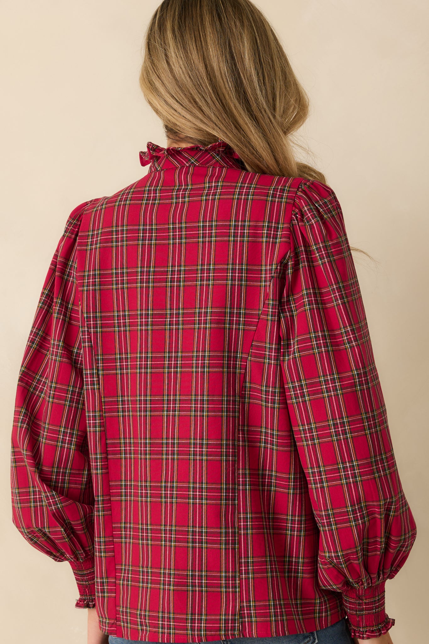 Rear view of the red plaid blouse showing the puff sleeves and smooth back with subtle shaping.