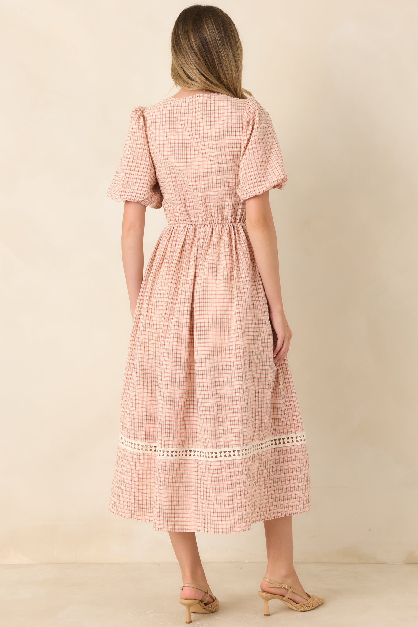 Rear view of the red and beige plaid midi dress showcasing the fitted bodice, puff sleeves, elastic waist, and full gathered skirt.
