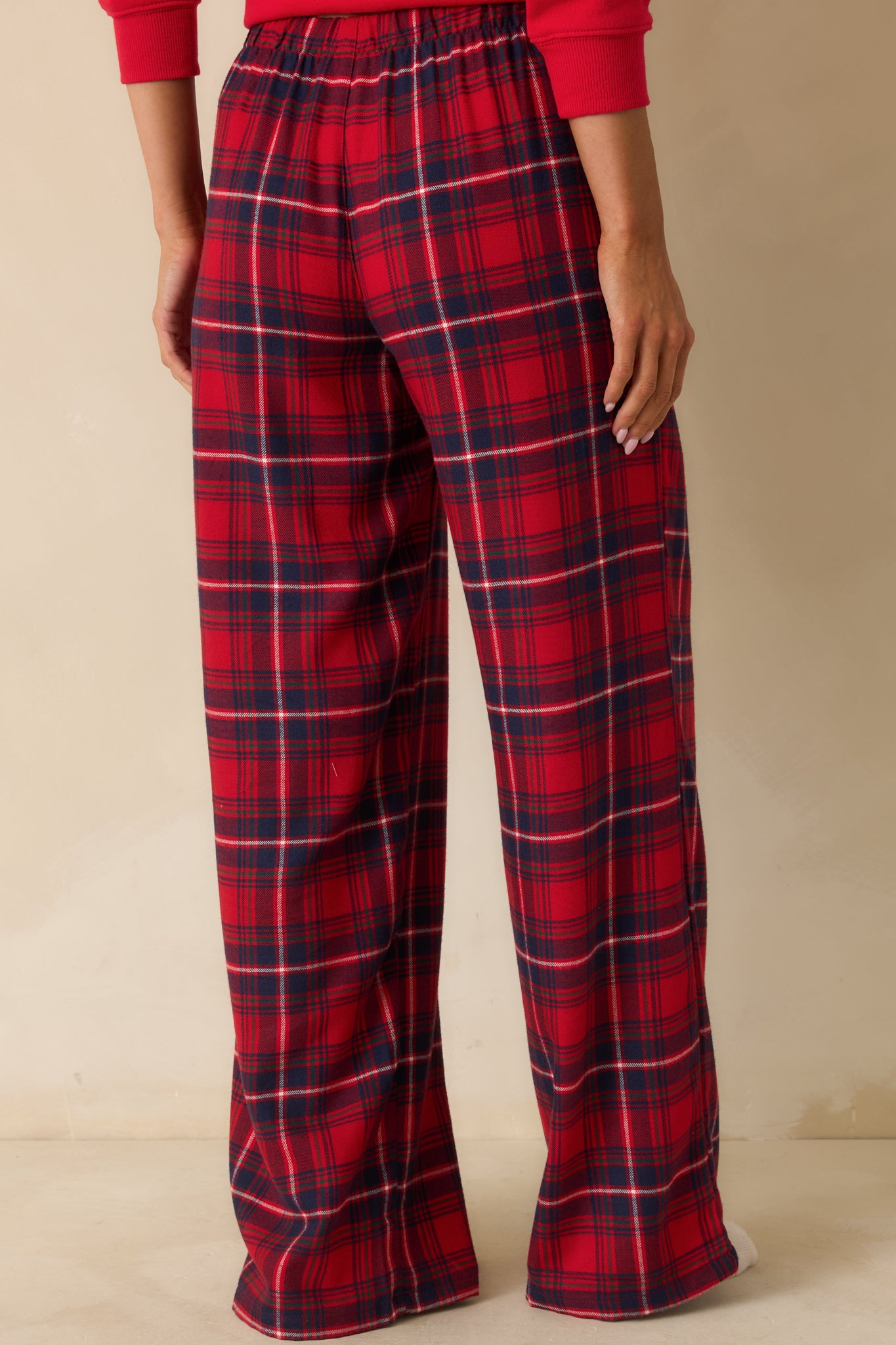 Rear view of red plaid pajama pants, showing straight-leg cut, elastic high-rise waistband, and smooth flannel finish.