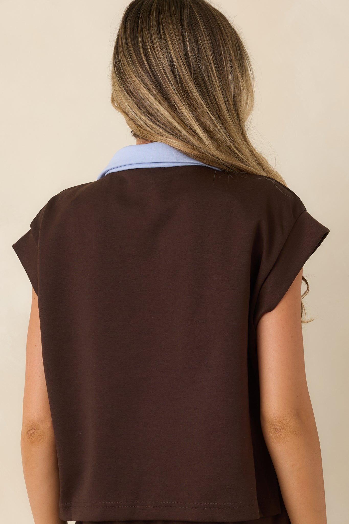 Rear view of the relaxed top highlighting the short cap sleeves, cropped hem, and smooth stretchy fabric.