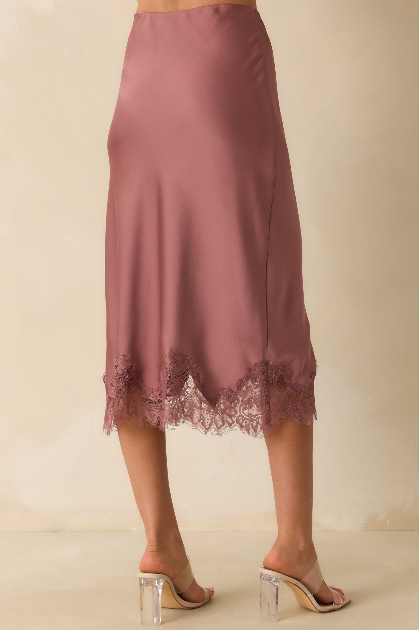 Rear view of the rose pink midi skirt showing the straight silhouette, pull-on design, and lace-trimmed hem.