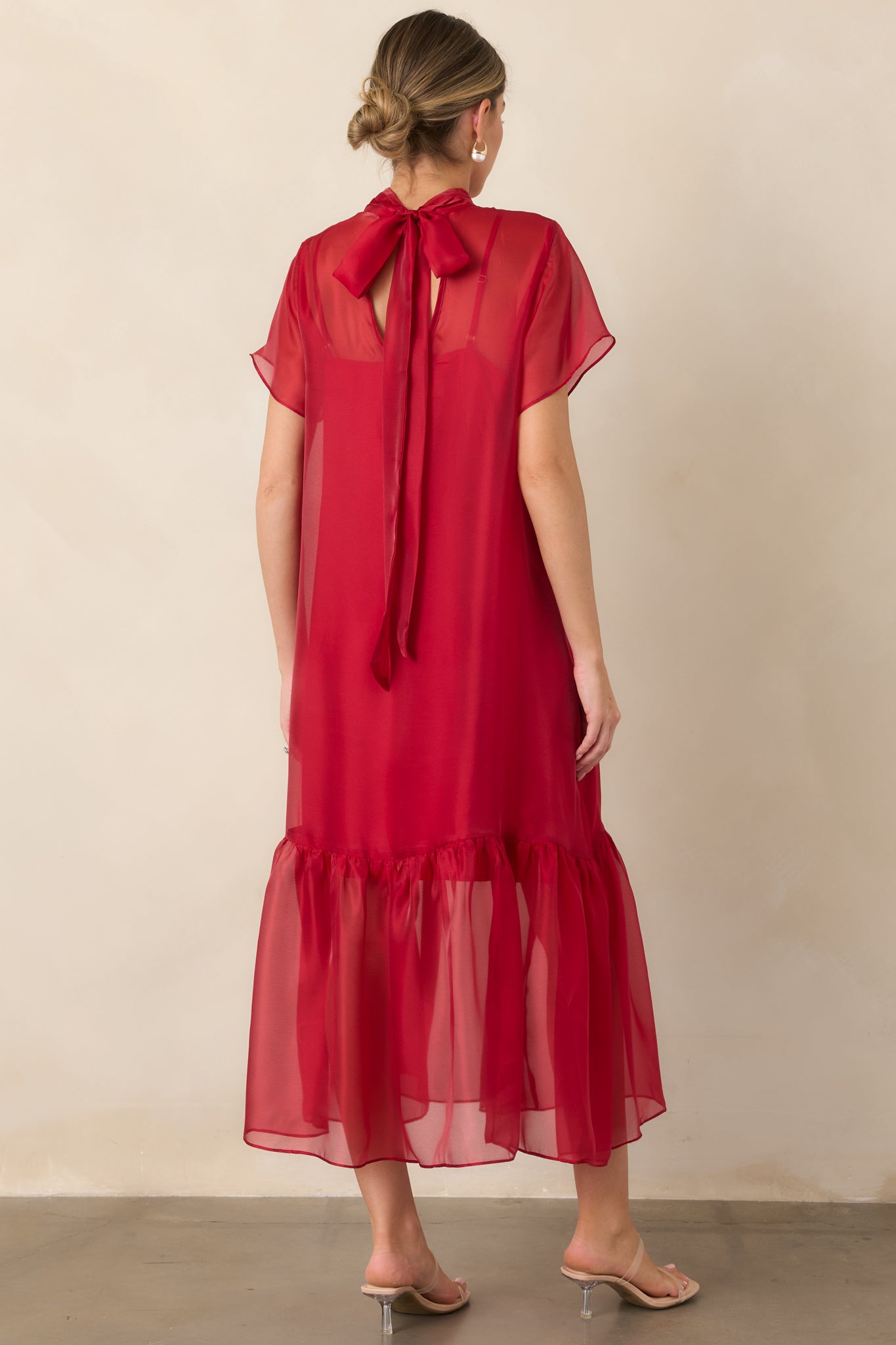 Rear view of the organza maxi dress showcasing the elegant tie-back neckline, sheer overlay, and gathered ruffle hem.