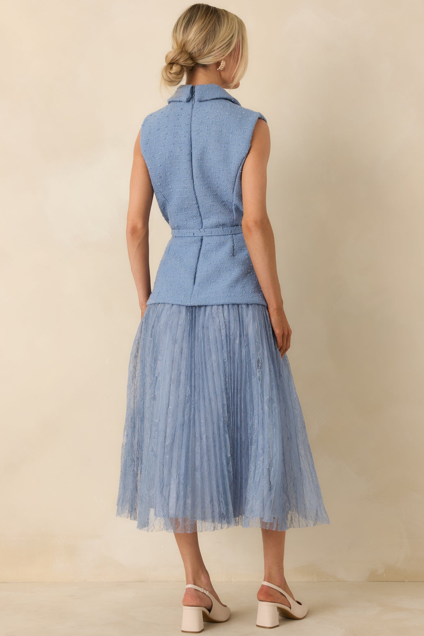 Rear view of cornflower blue midi dress showing concealed back zipper and softly structured silhouette.