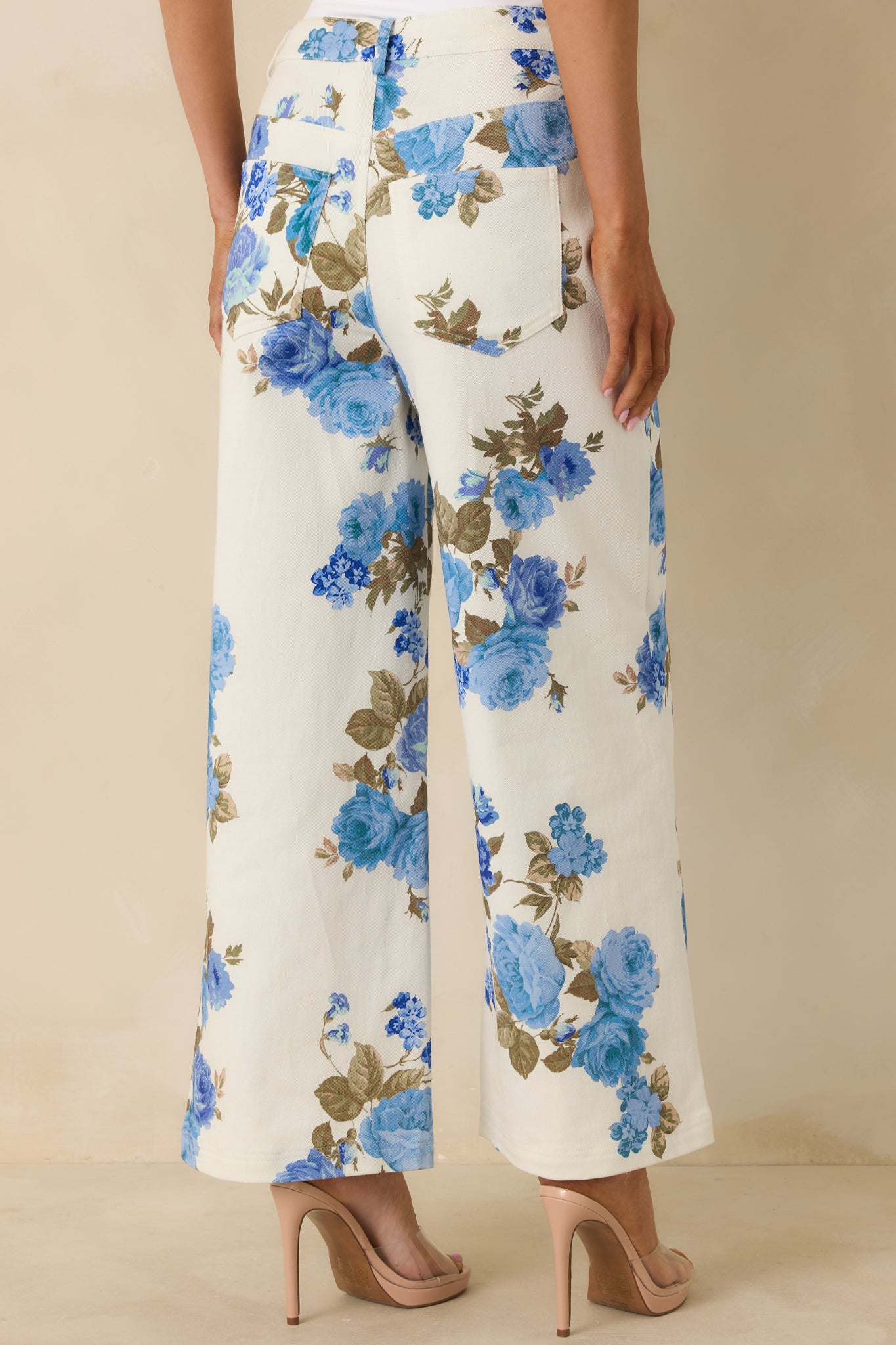 Rear view of the blue floral pants showing functional rear pockets, high-rise fit, and wide-leg silhouette.