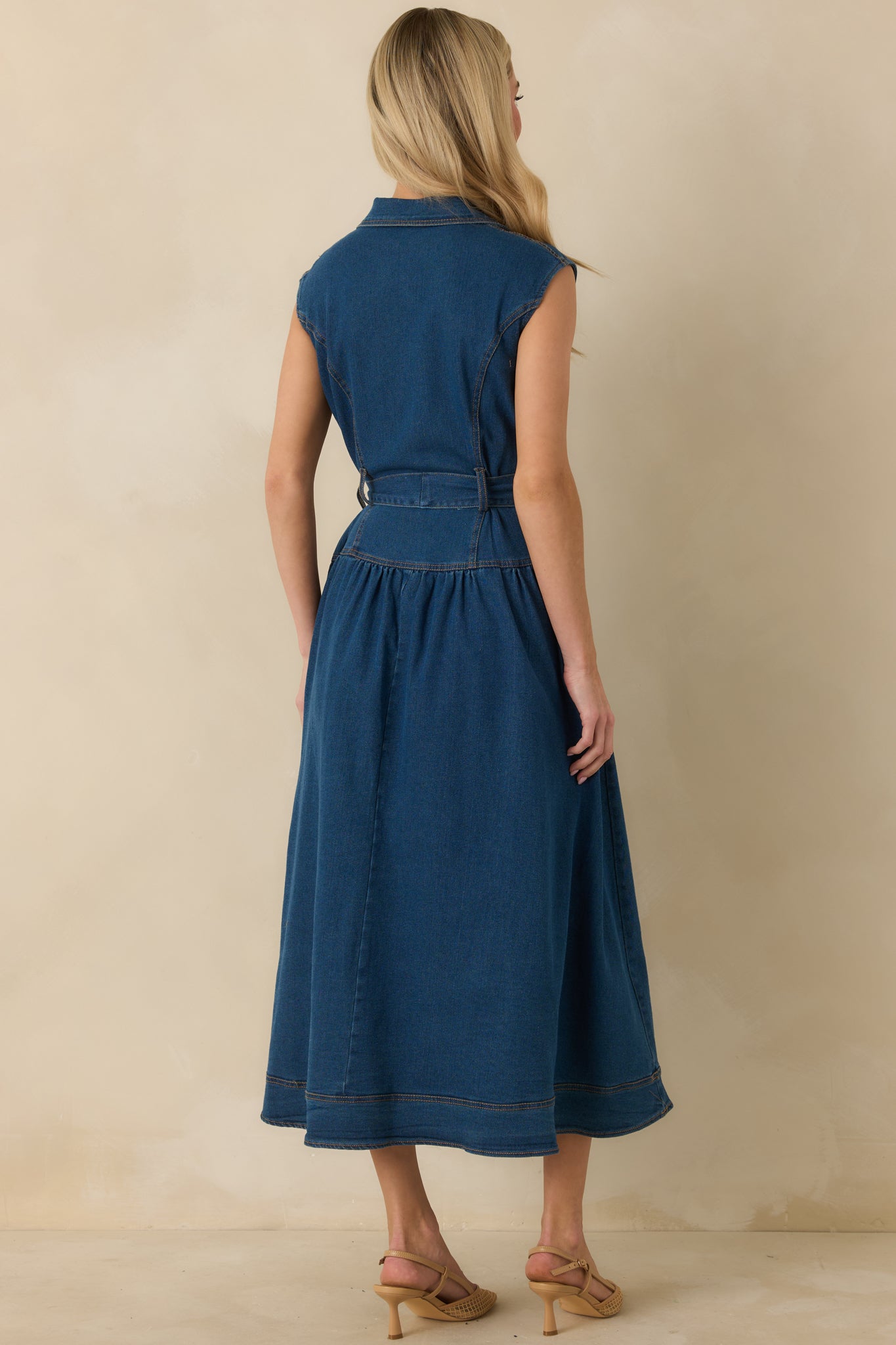 Rear view of the dark wash denim midi dress showing sleeveless cut, gathered A-line skirt, and smooth back finish.