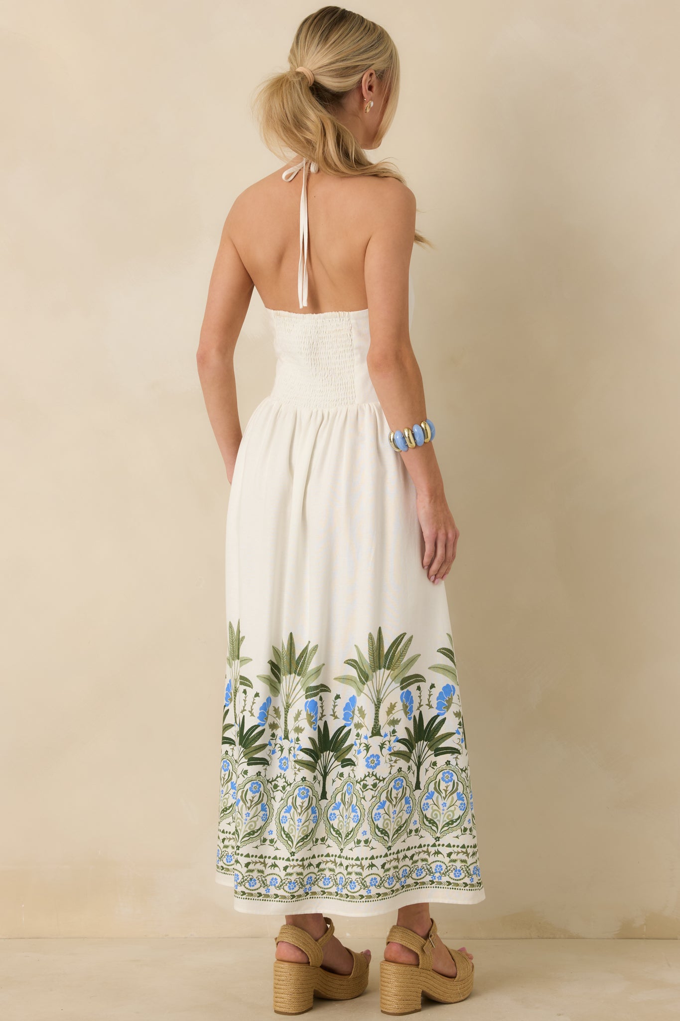 Rear view of ivory midi dress showing open back with smocked panel and tie-back closure.