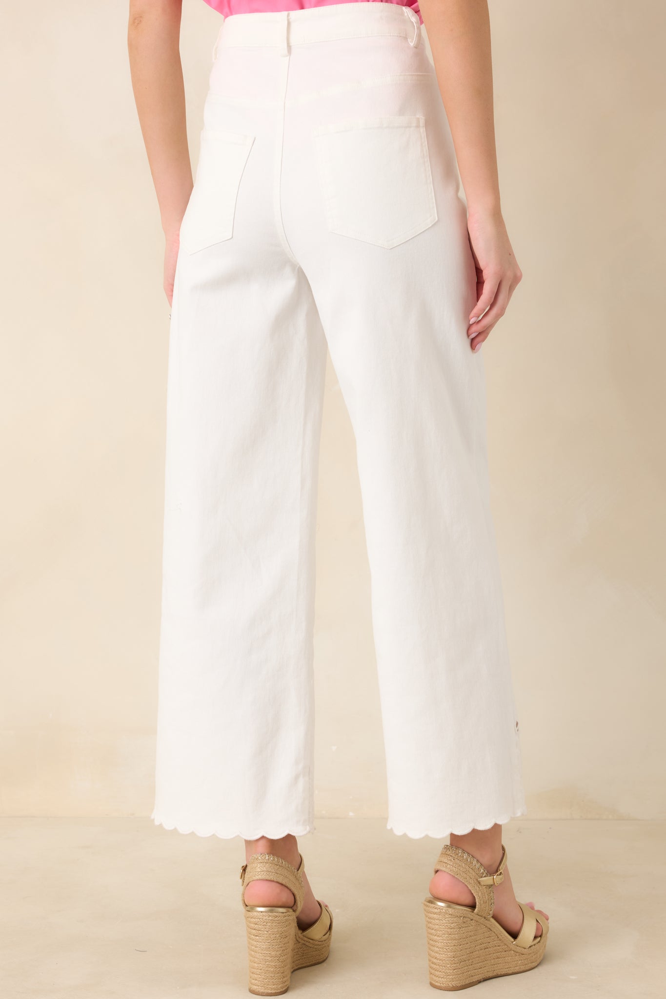 Rear view of the ivory wide-leg pants showing subtle shaping and a structured waistband for a smooth silhouette.