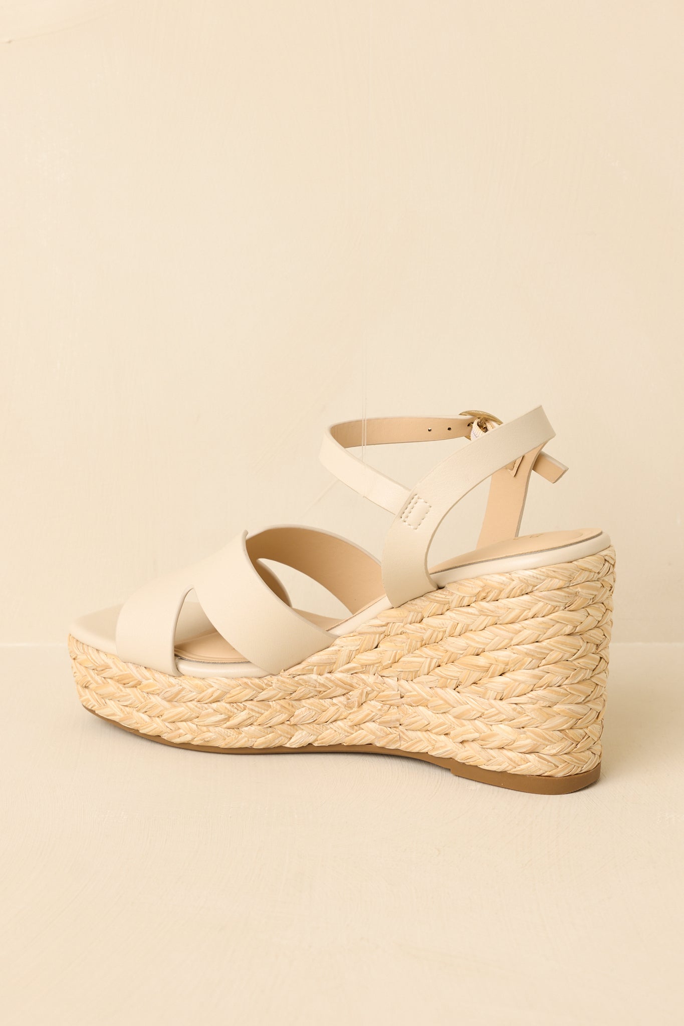 Rear view of the wedge sandals showing the heel structure, ankle strap fit, and woven espadrille finish.