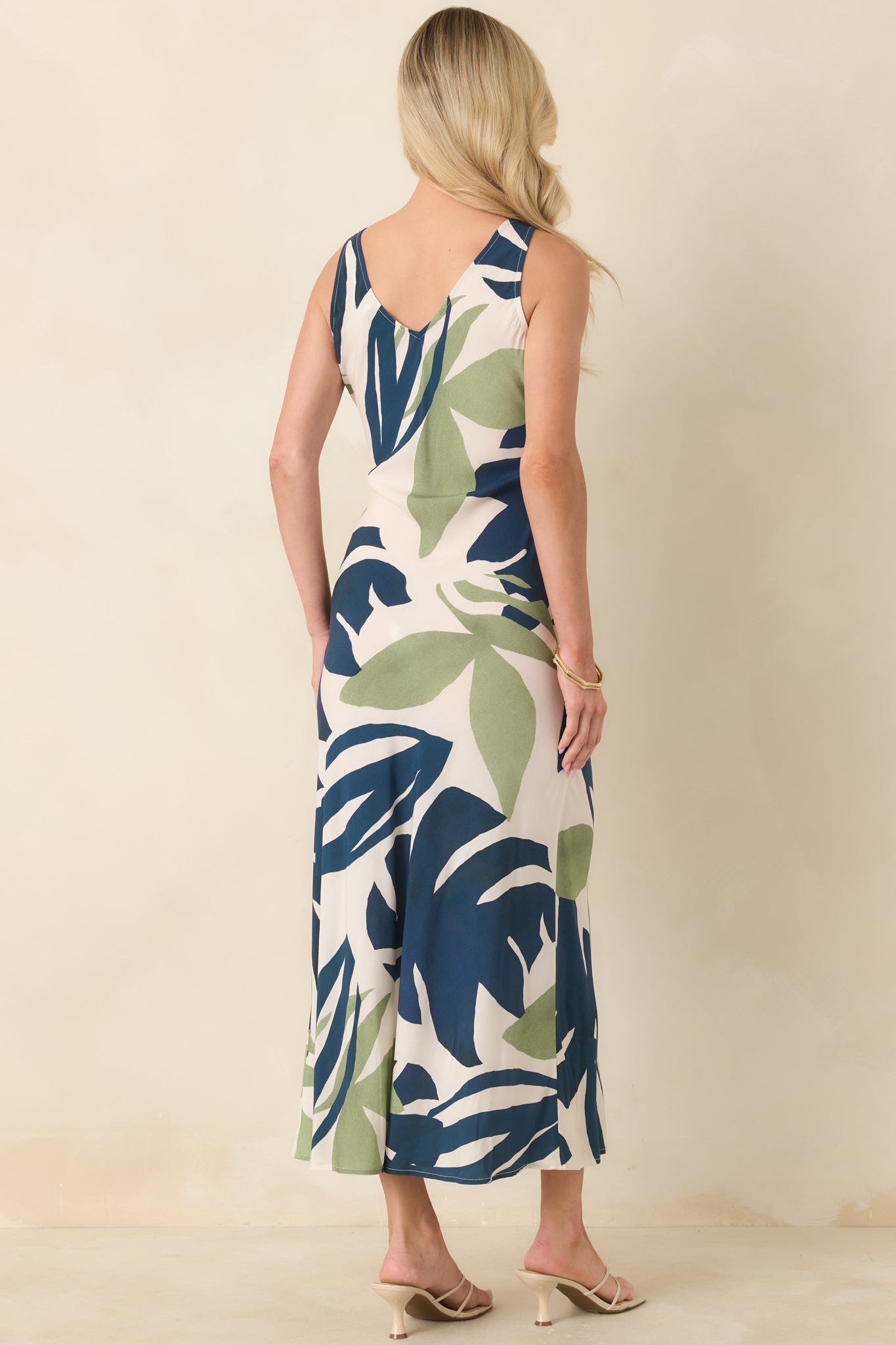 Rear view of the palm print midi dress showing the sleeveless silhouette and smooth, flowing drape along the back.