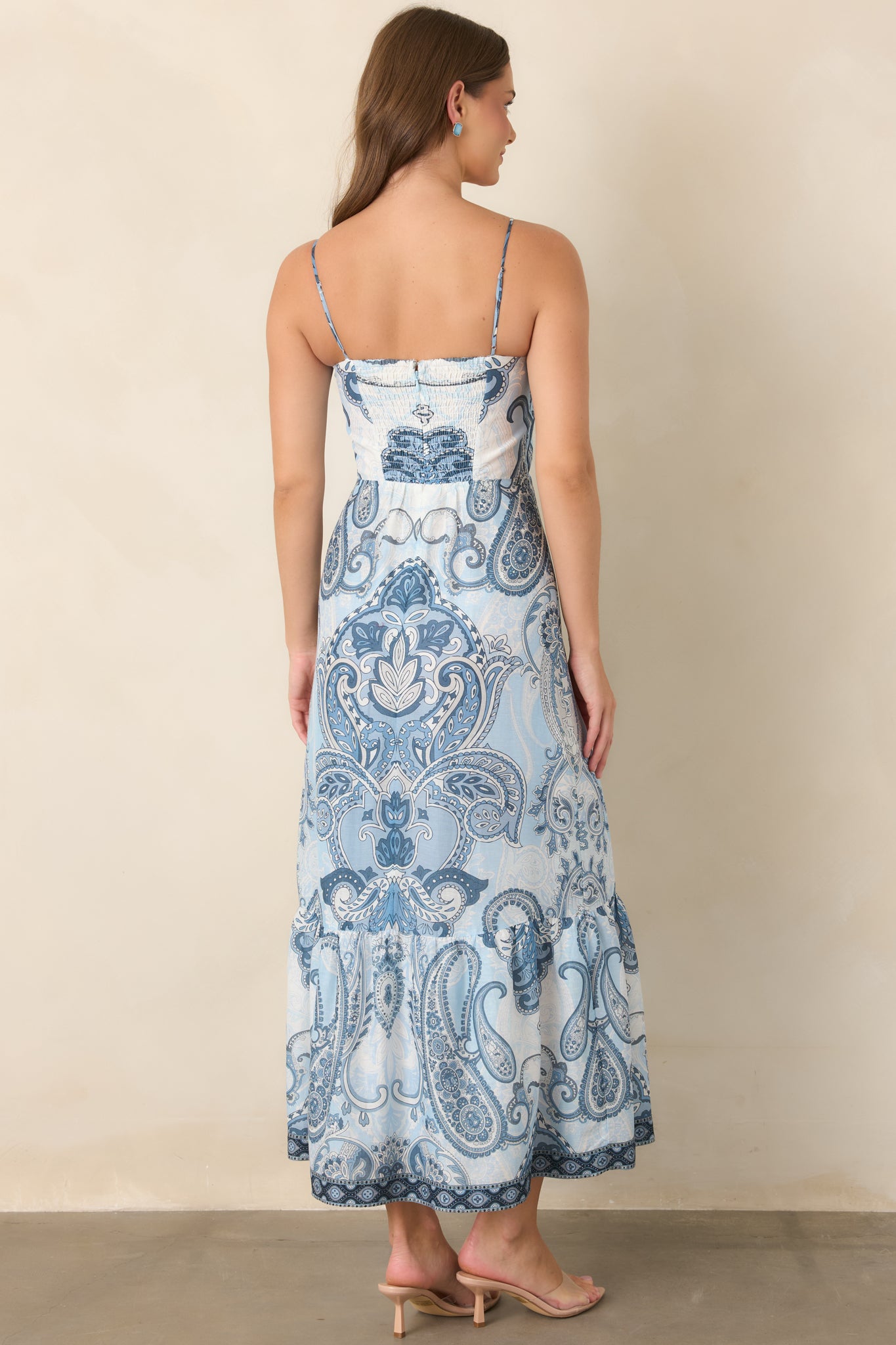 Rear view of the blue-and-ivory midi dress showing the smocked back, adjustable straps, tiered skirt, and concealed zipper.