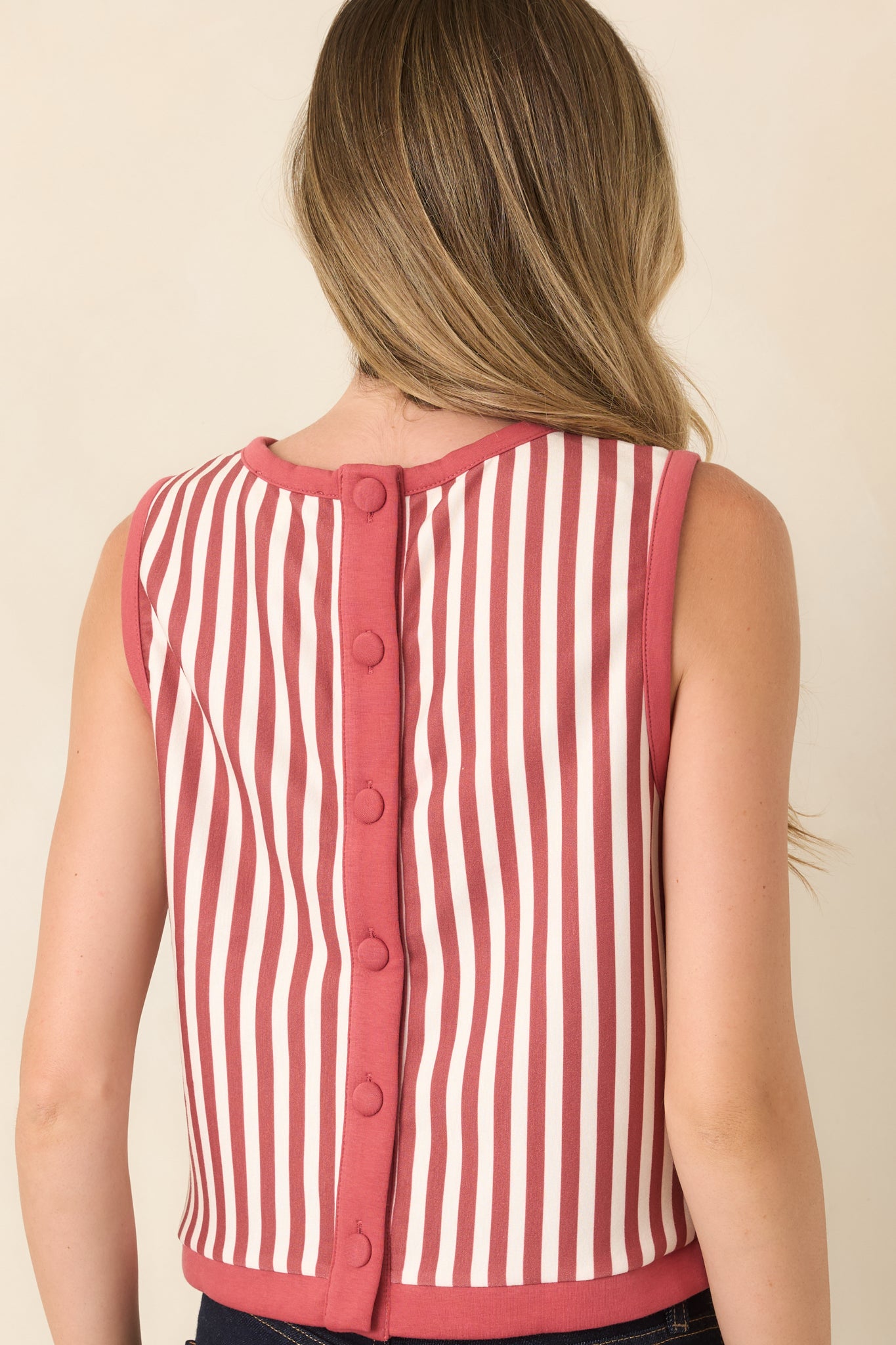 Rear view of the striped sleeveless top showcasing its button-down back, rounded neckline, contrast trim, and cropped silhouette.