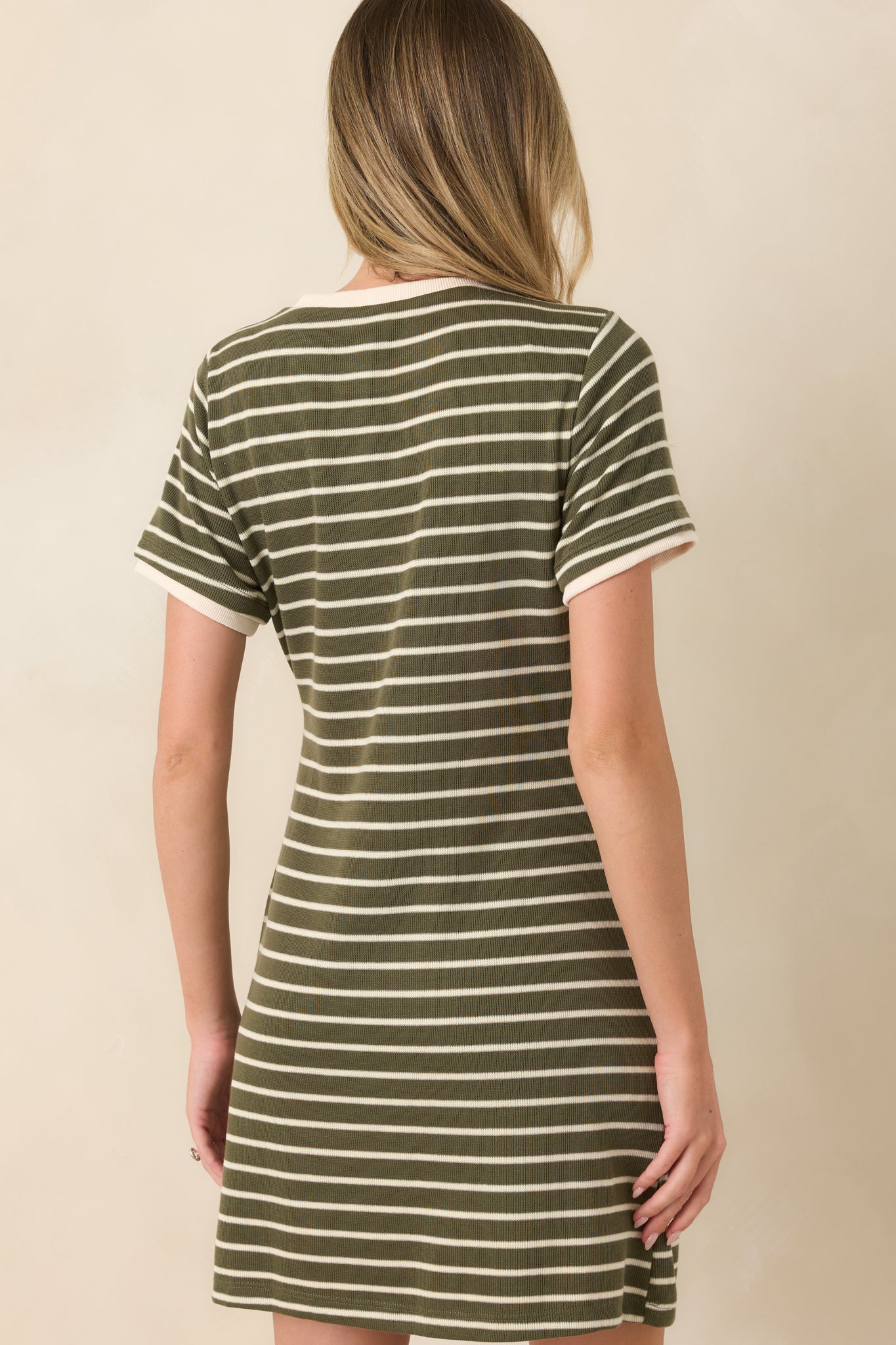 Rear view of the striped mini dress highlighting the continuous stripe pattern, short sleeves, and relaxed knit silhouette.