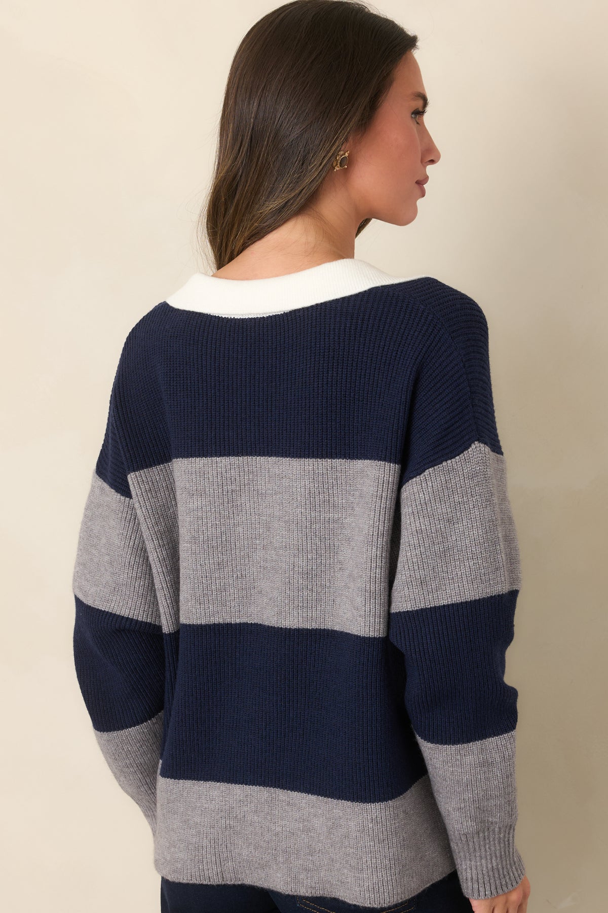 Rear view of the striped ribbed knit top with long sleeves and hip-length hem.
