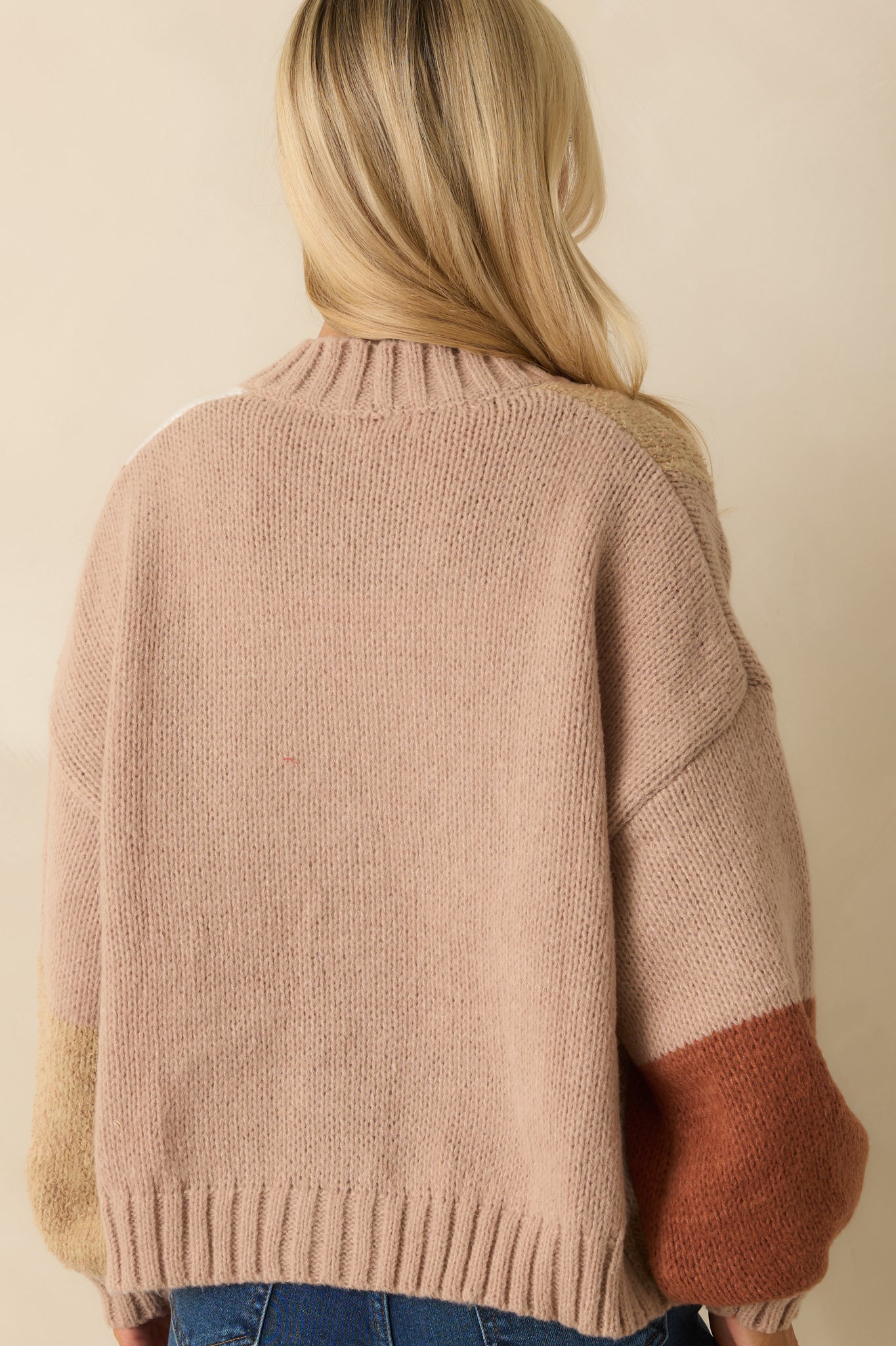 Rear view of taupe color block cardigan highlighting relaxed fit, balloon sleeves, and ribbed hem.