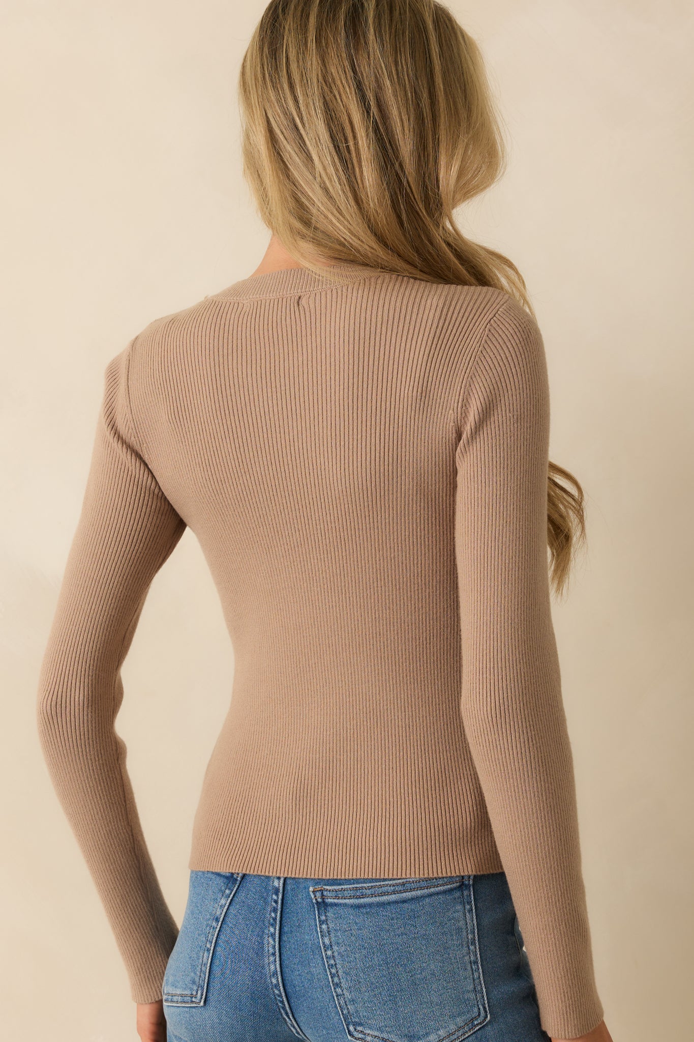 Rear view of taupe sweater showing fitted silhouette and long sleeves.