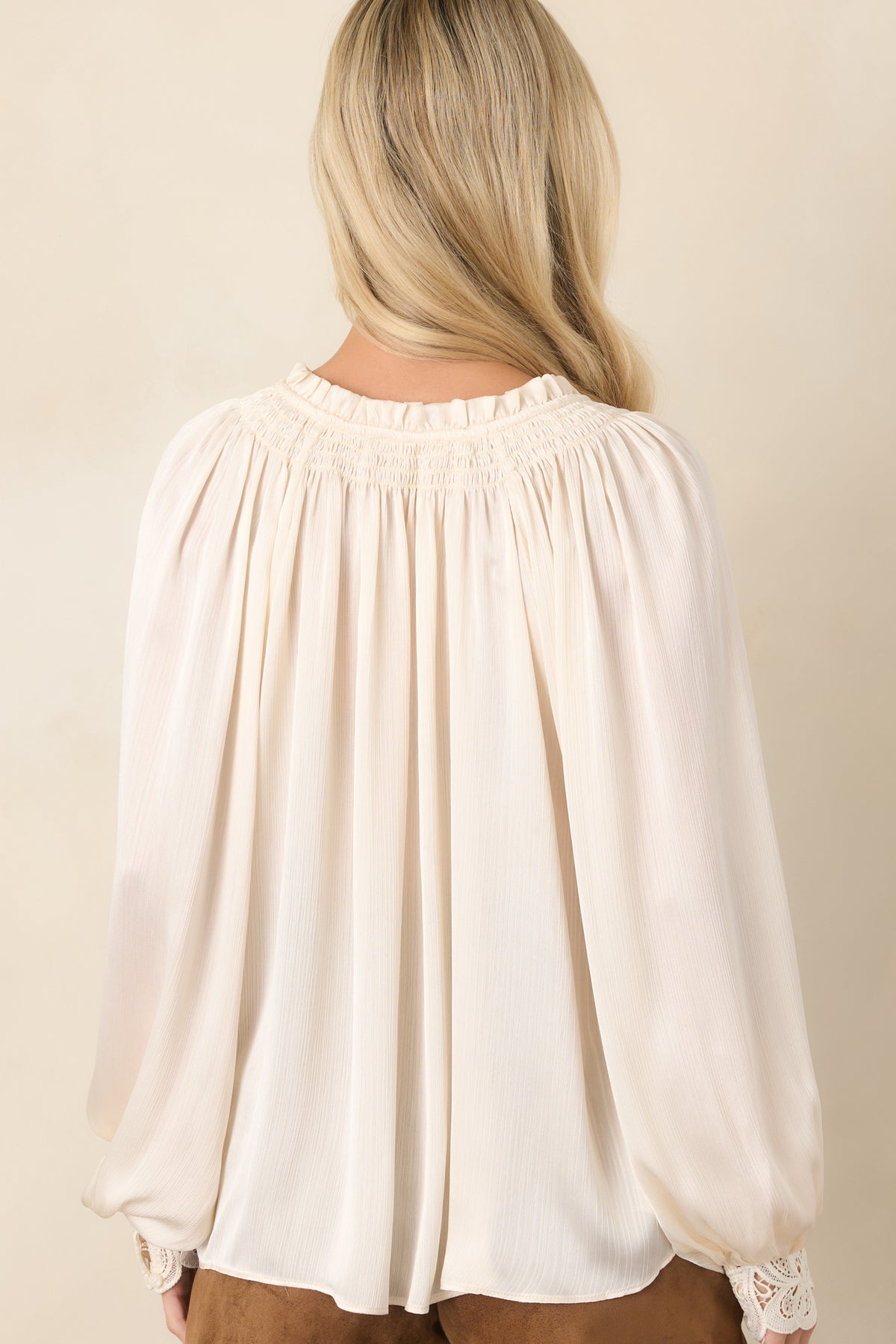 Rear view of the textured top showing the relaxed silhouette and gathered balloon sleeves