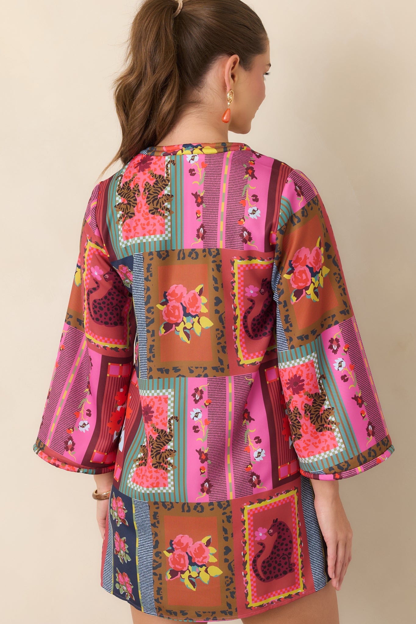 Rear view of the Vintage Vignette mini dress showcasing its relaxed A-line silhouette, wide three-quarter sleeves, corded trim, and colorful statement print.