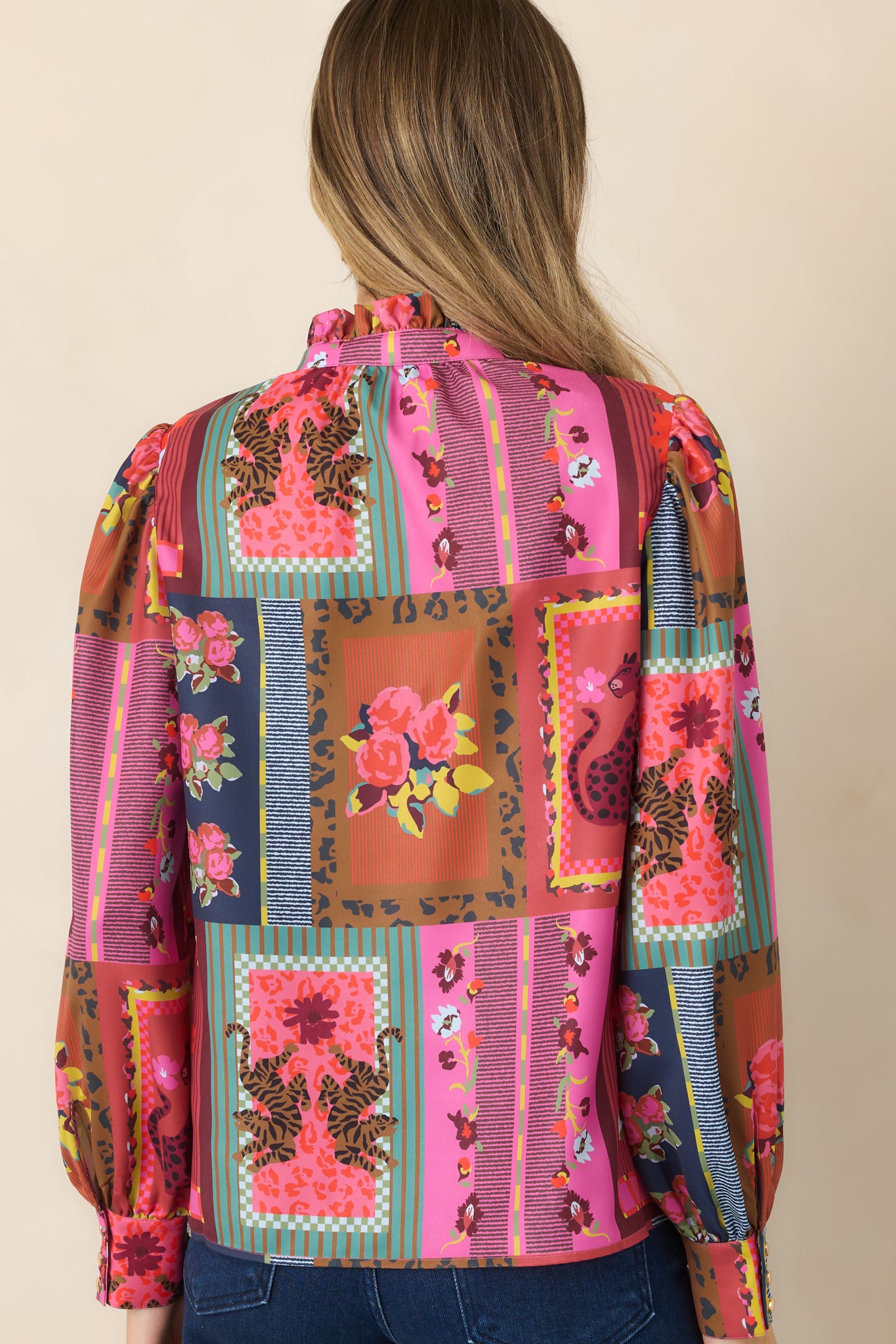 Rear view of the Vintage Vignette top showcasing its flowing silhouette, gathered shoulders, long blouson sleeves, buttoned cuffs, and colorful patchwork-inspired print.