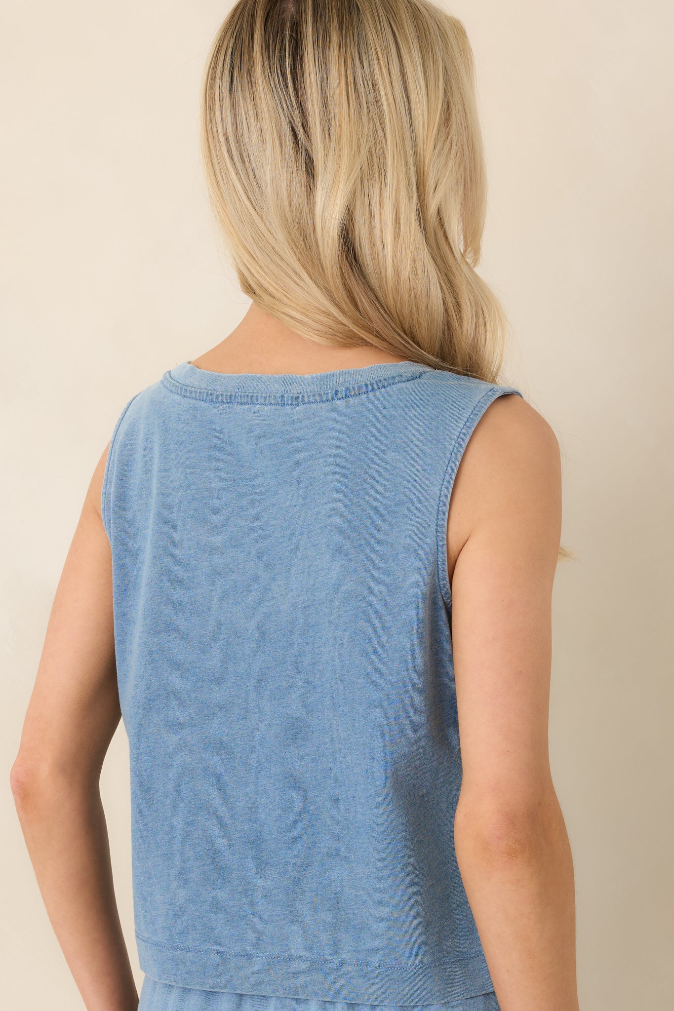 Rear view of washed indigo tank with sleeveless design and straight hem.