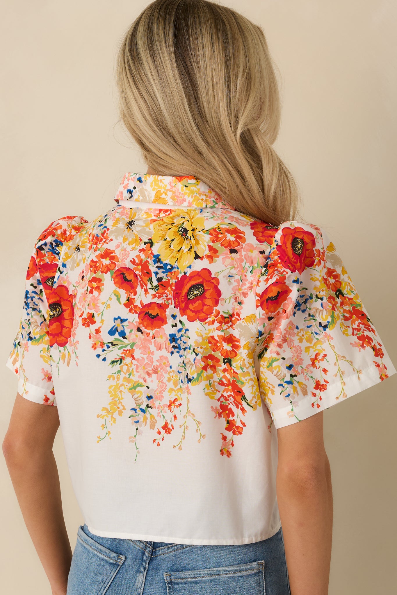 Rear view of the white cotton floral top showing the relaxed silhouette, short sleeves, and continuous multicolor print.