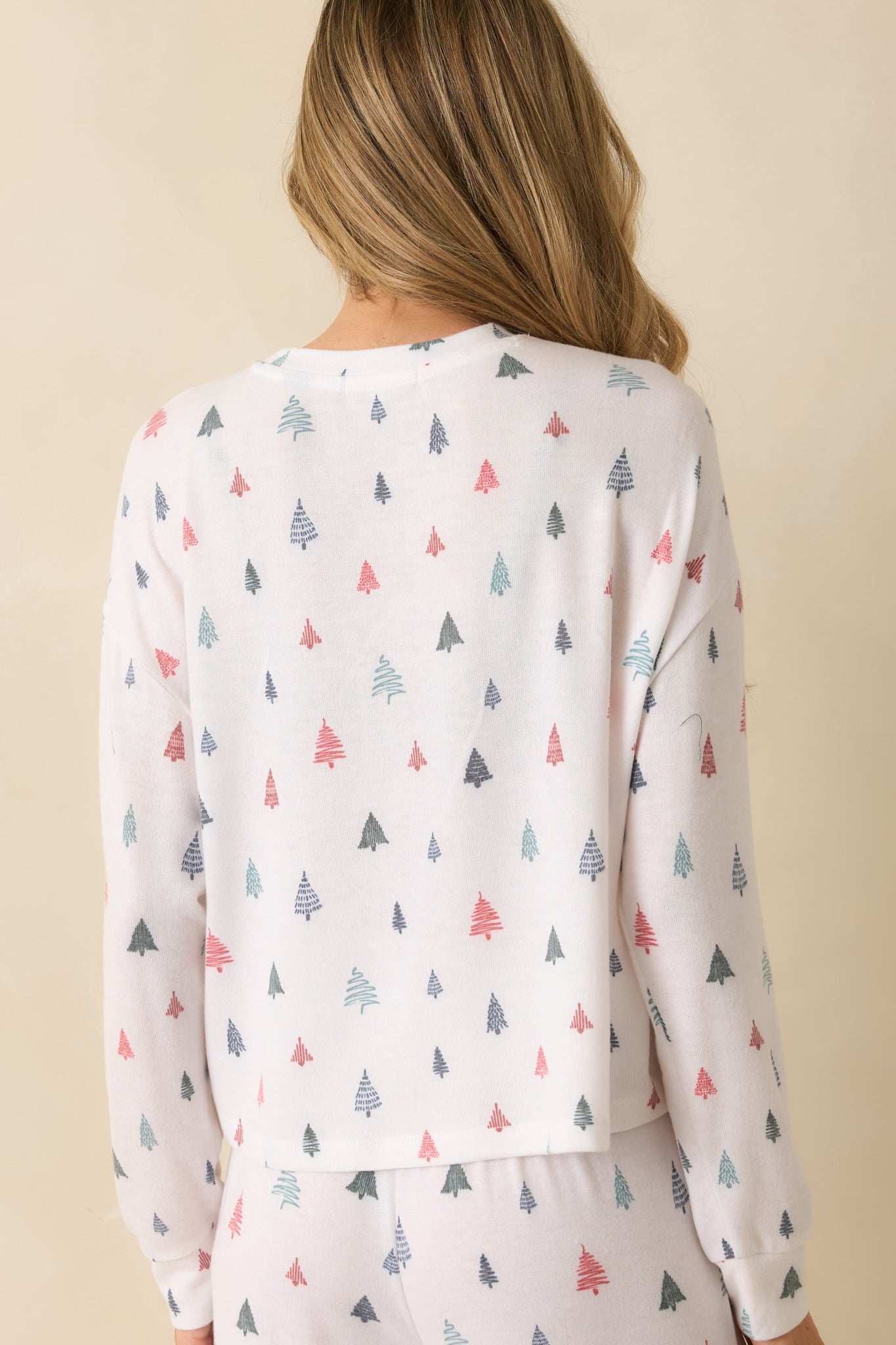 Rear view of white long-sleeve pajama top, showing relaxed fit, crew neckline, and allover alpine tree motif.