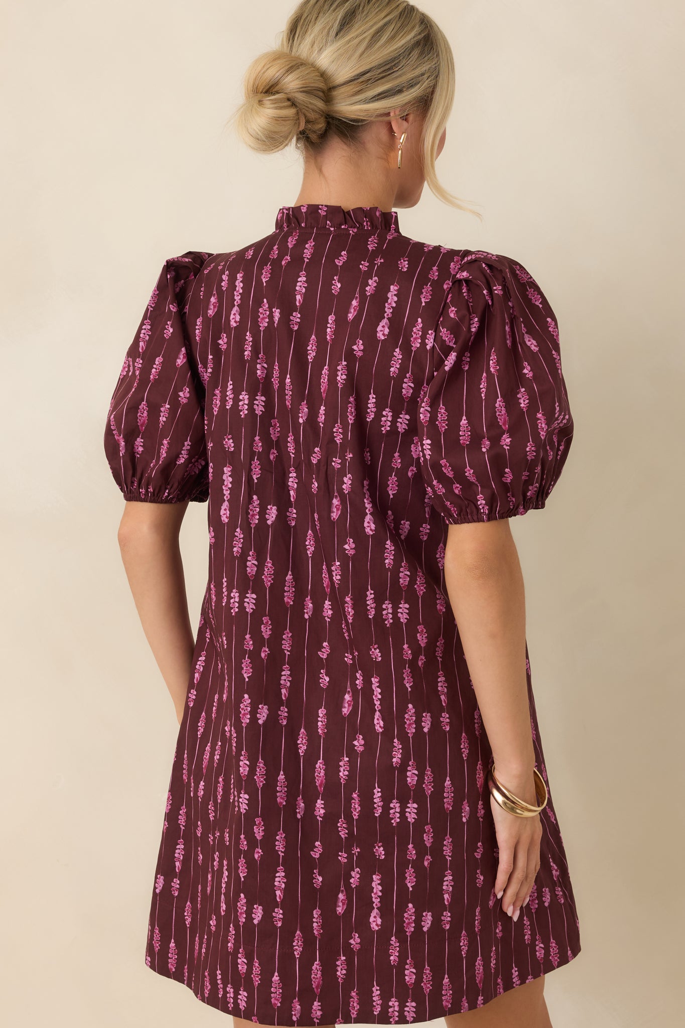 Rear view of the wine mini dress highlighting the vertical stripe print, puff sleeves, and relaxed shape.