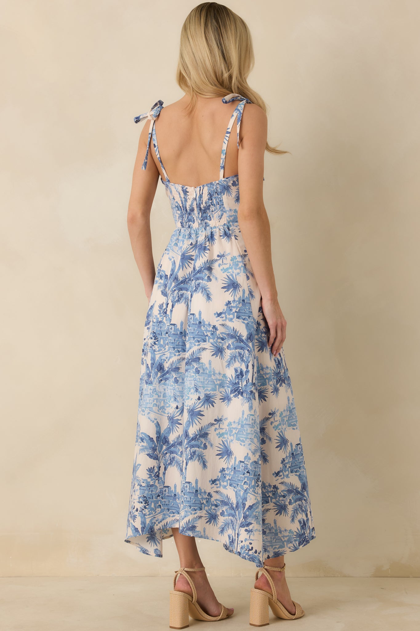 Rear view of blue and ivory maxi dress with smocked panel and zip closure.