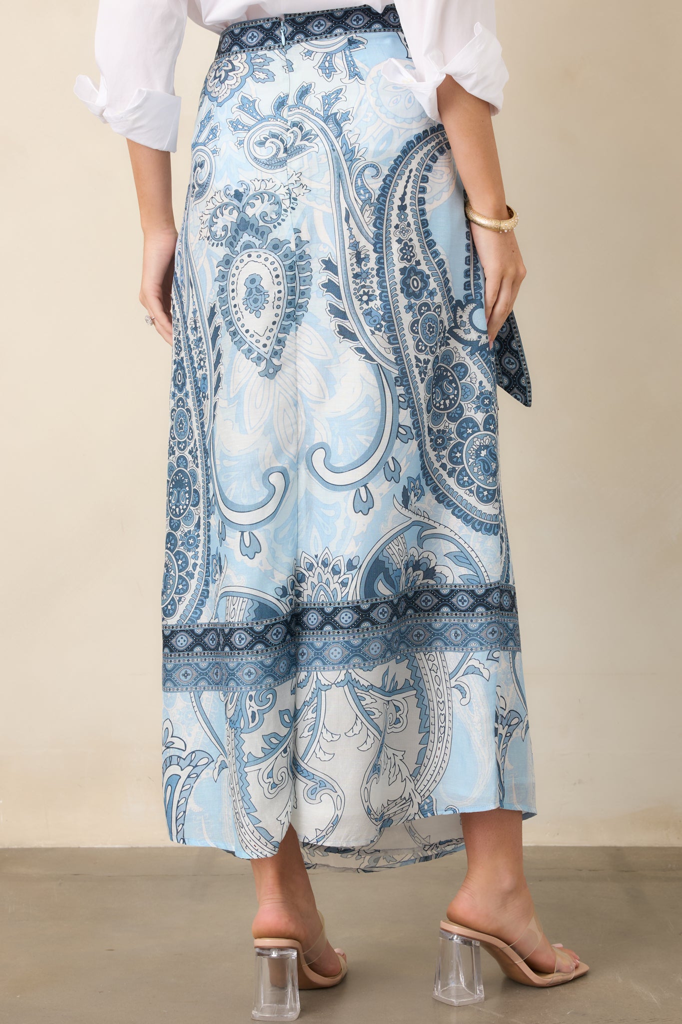 Rear view of the flowing wrap maxi skirt showcasing its long silhouette, soft cotton lining, and printed border detail.