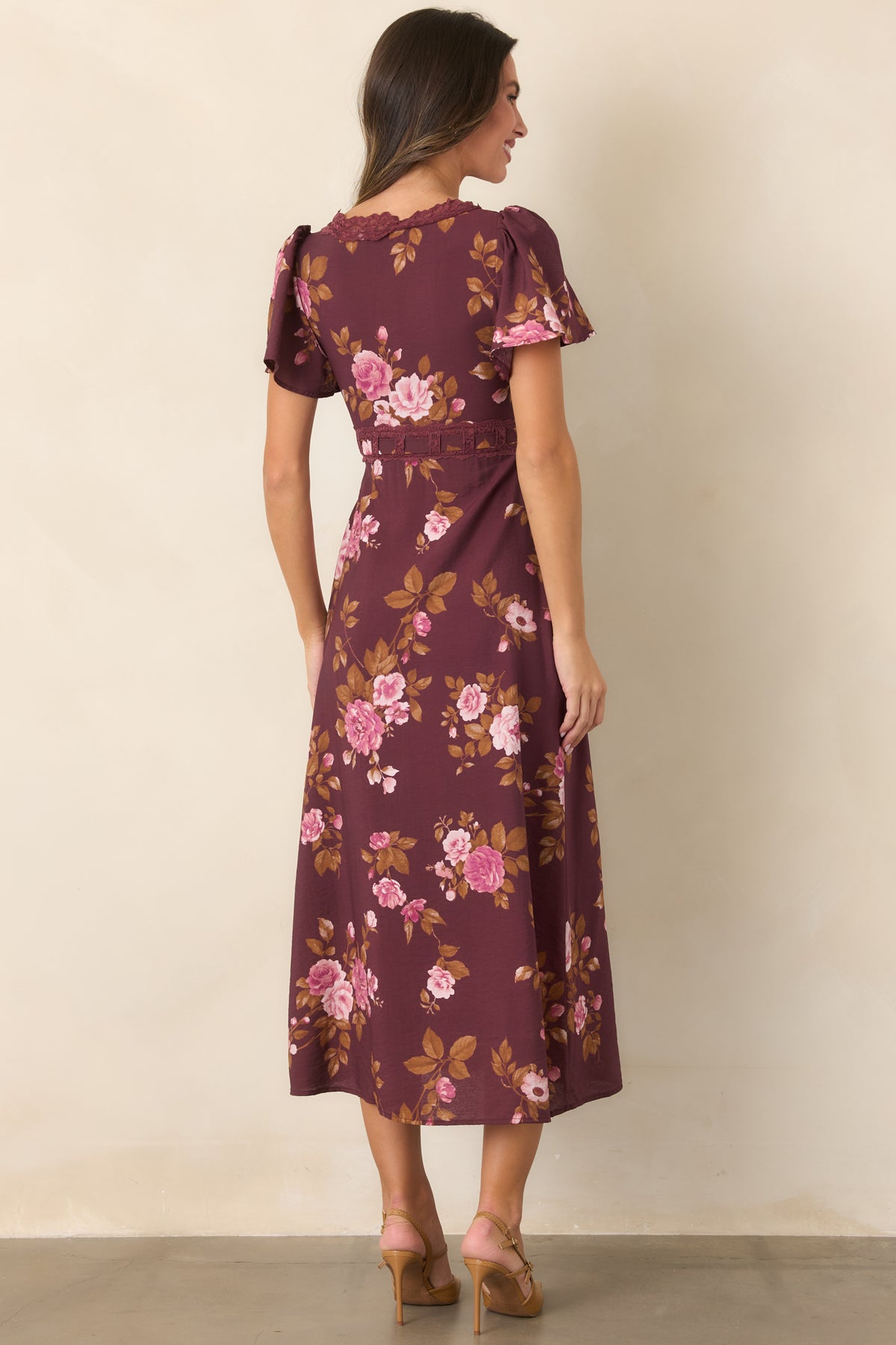 Rear of the wine floral midi dress featuring the allover pink and golden brown print, flutter sleeves, and softly flared skirt.