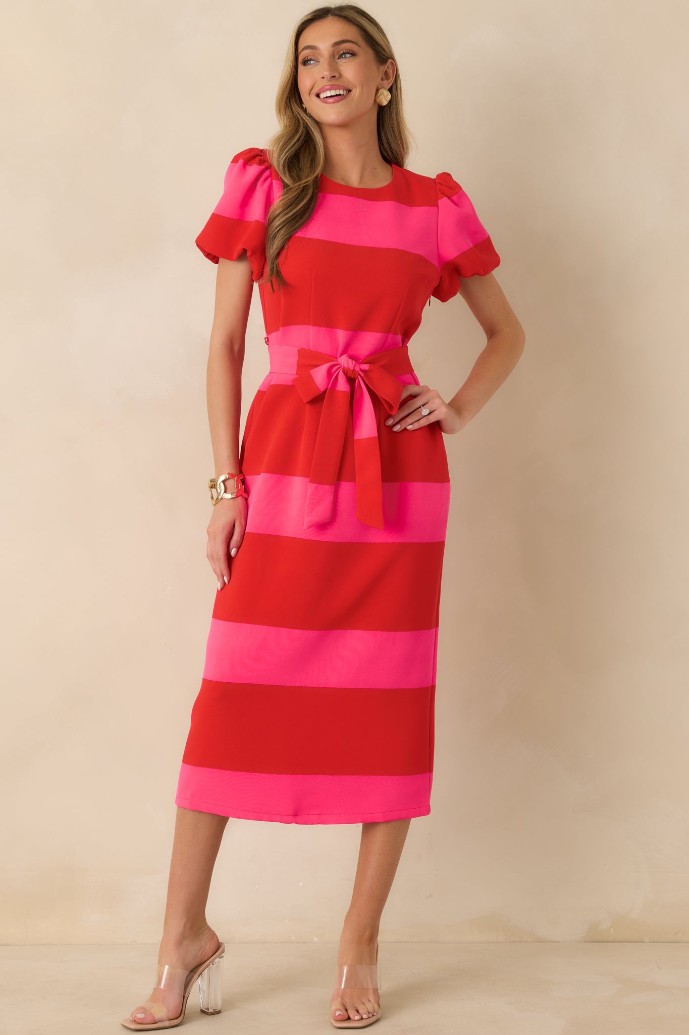 Red and pink striped dress showcasing a polished, body-skimming silhouette and mid-length skirt.
