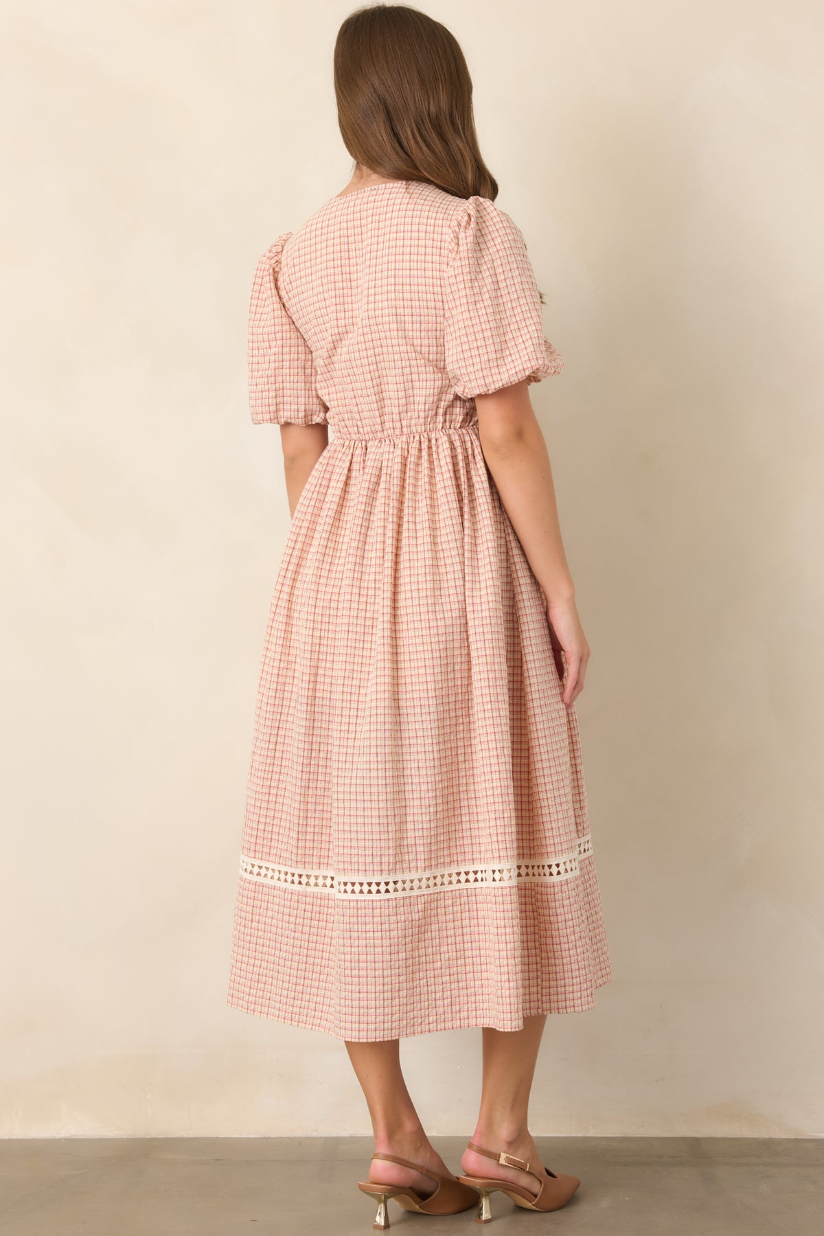 Rear view of the red and beige plaid midi dress showcasing the fitted bodice, puff sleeves, elastic waist, and full flowing skirt.