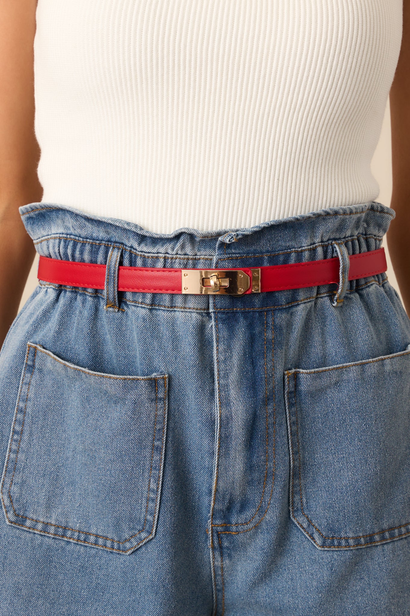 Red belt with smooth material and gold twist-lock closure shown from the front.