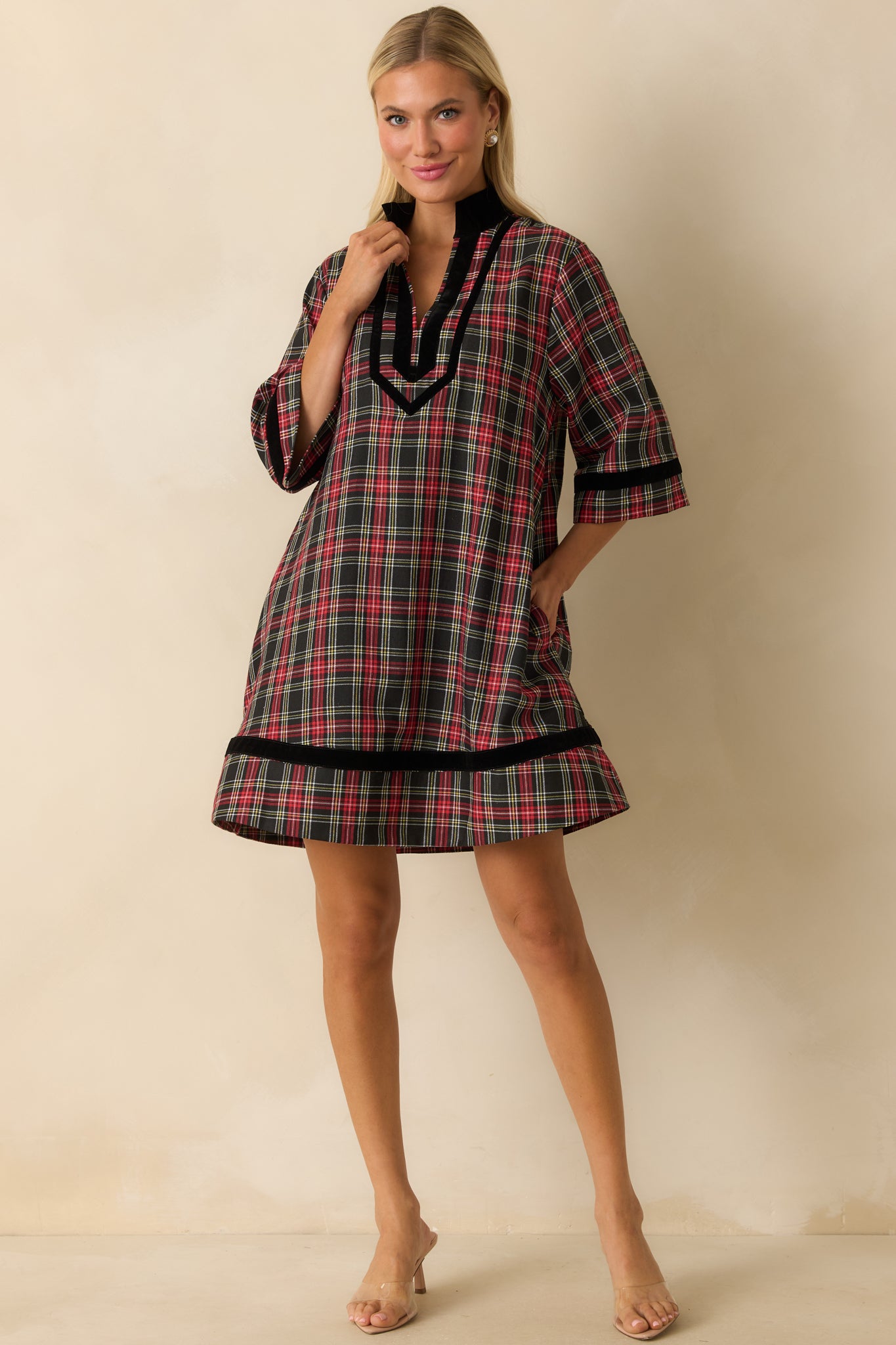 Red and black plaid mini dress with split neckline, elbow-length sleeves, side pockets, and relaxed A-line fit.