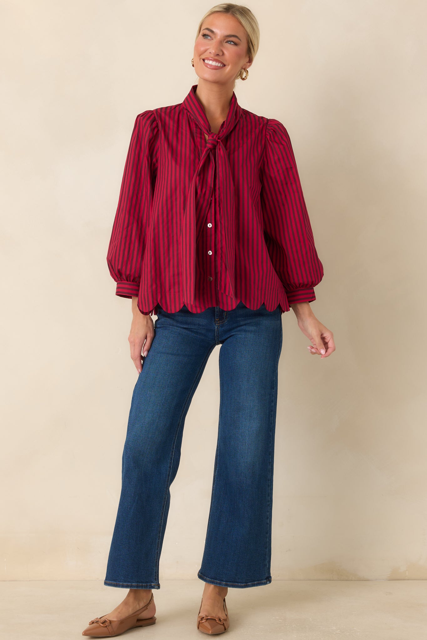Red and brown striped top showcasing a versatile tie neckline, softly gathered shoulders, and a relaxed feminine silhouette.
