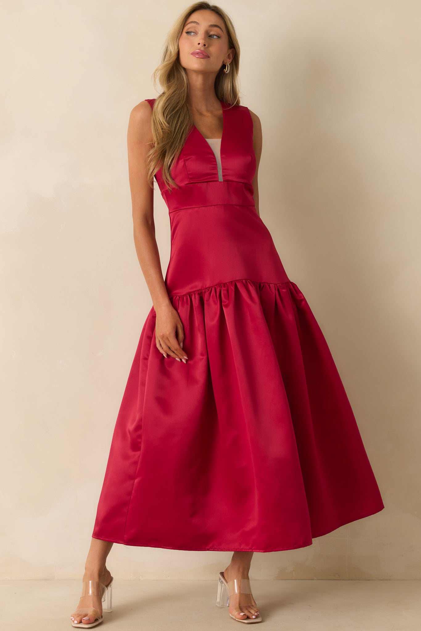 Fitted red dress featuring princess seams and a drop waist silhouette.