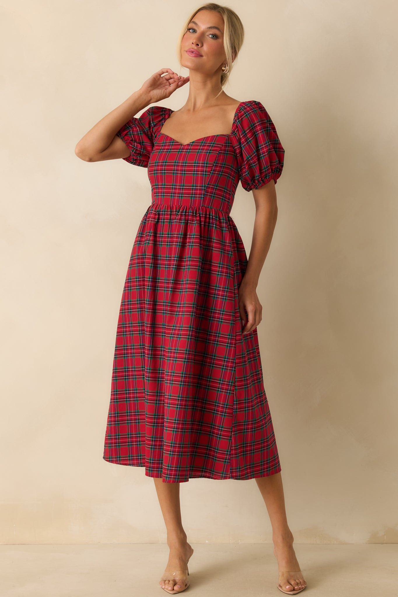 Red dress highlighting a sweetheart neckline, short puff sleeves, and structured plaid design.