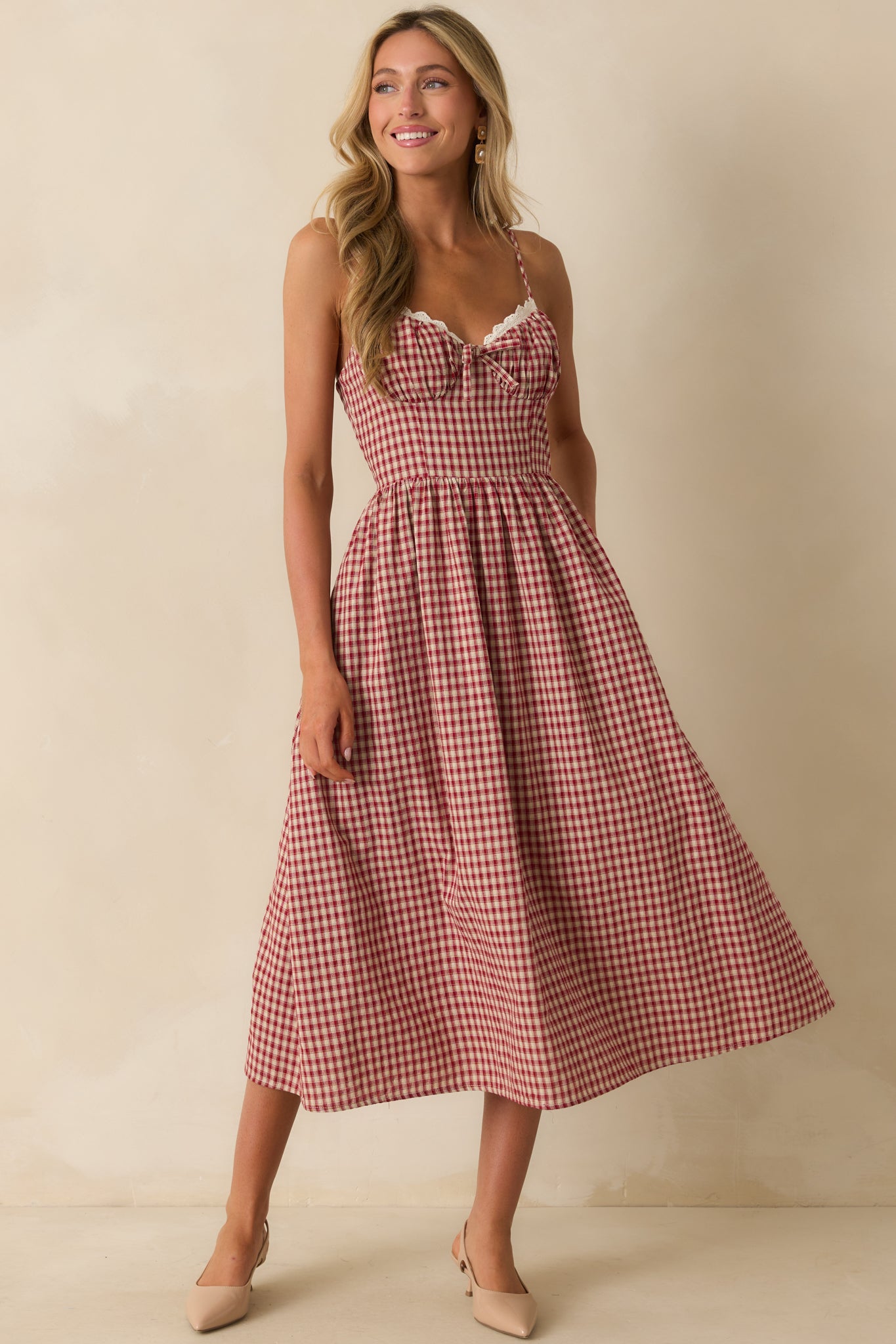 Red gingham midi dress with sweetheart neckline trimmed in ivory scalloped lace and adjustable spaghetti straps.