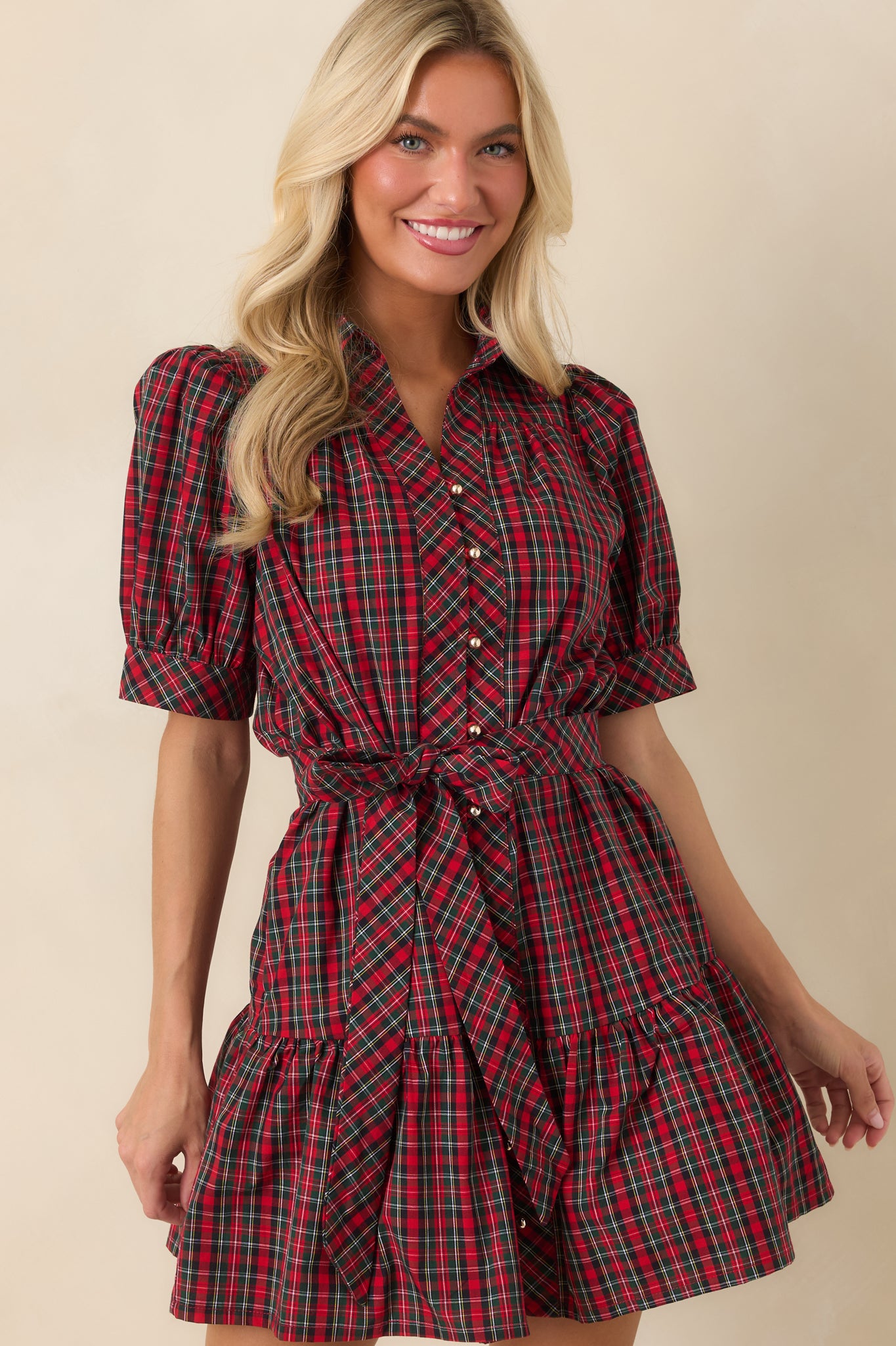Red and green plaid dress showcasing gathered puff sleeves, polished buttons, and a classic collared design.