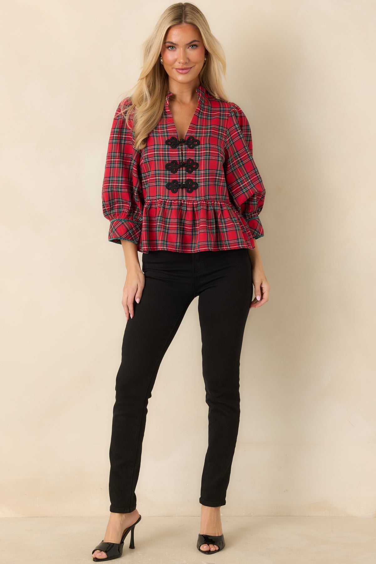 Red and green plaid top featuring a stand collar, split neckline, three black braided frog closures, and a gathered peplum hem.