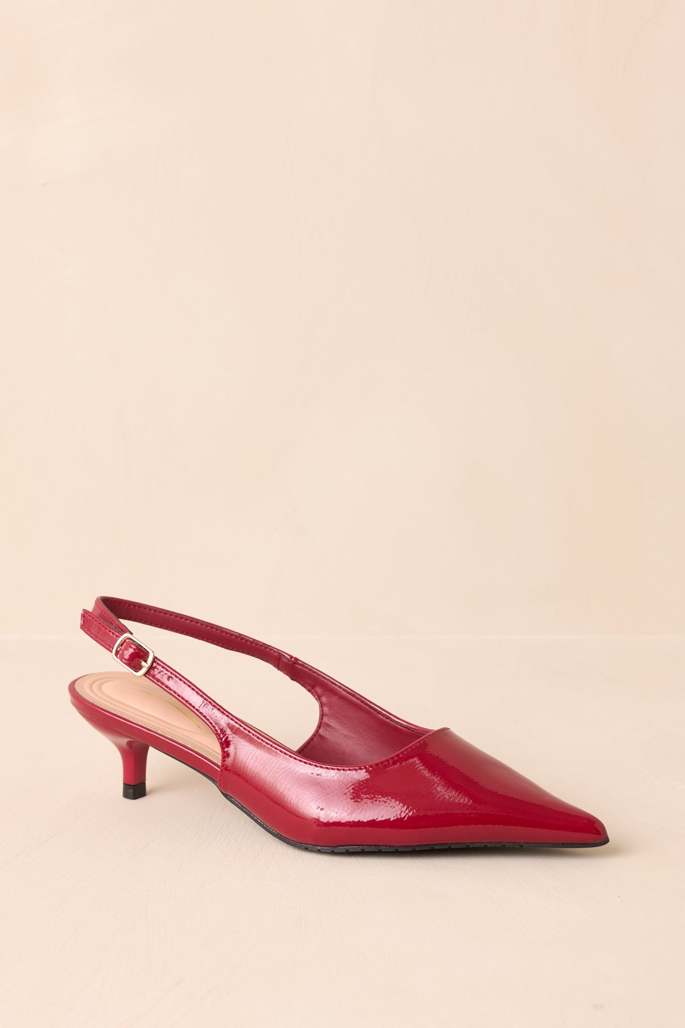 Angled view of the red heels showing both the slingback strap and pointed toe.