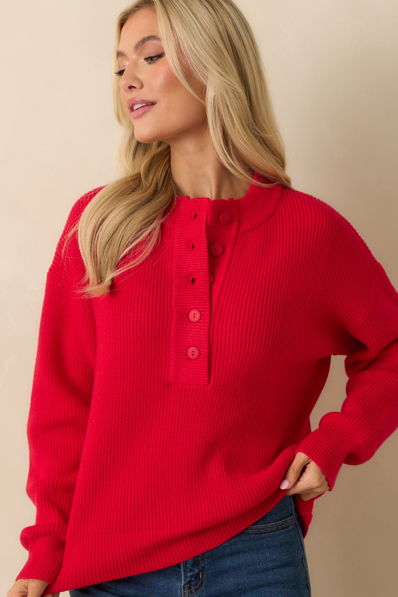 Red henley knit sweater shown up close to highlight cozy texture and easy, relaxed fit.