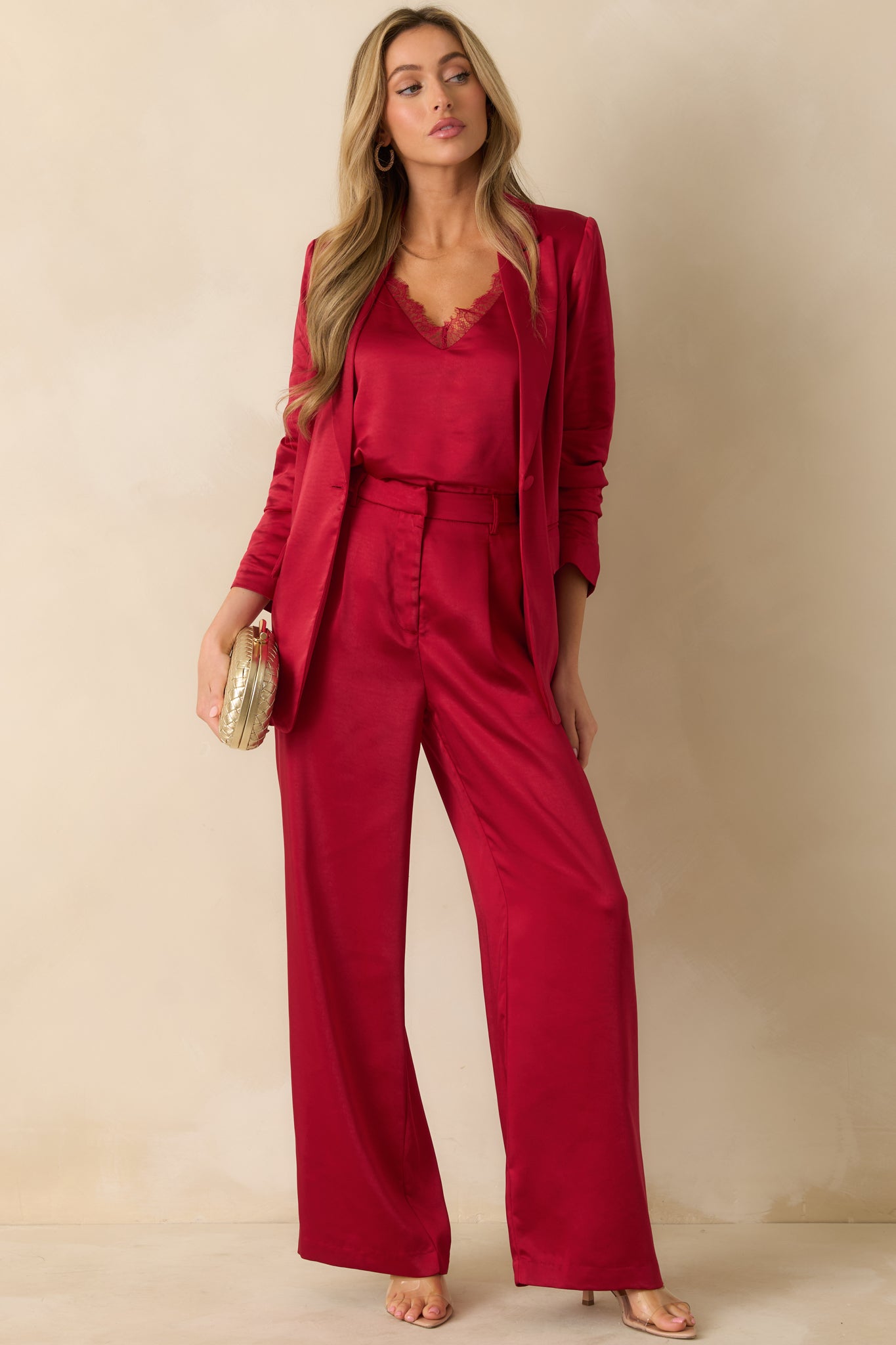 Red high-waisted pants with a wide-leg silhouette, pleated front, side pockets, and polished belt loops.