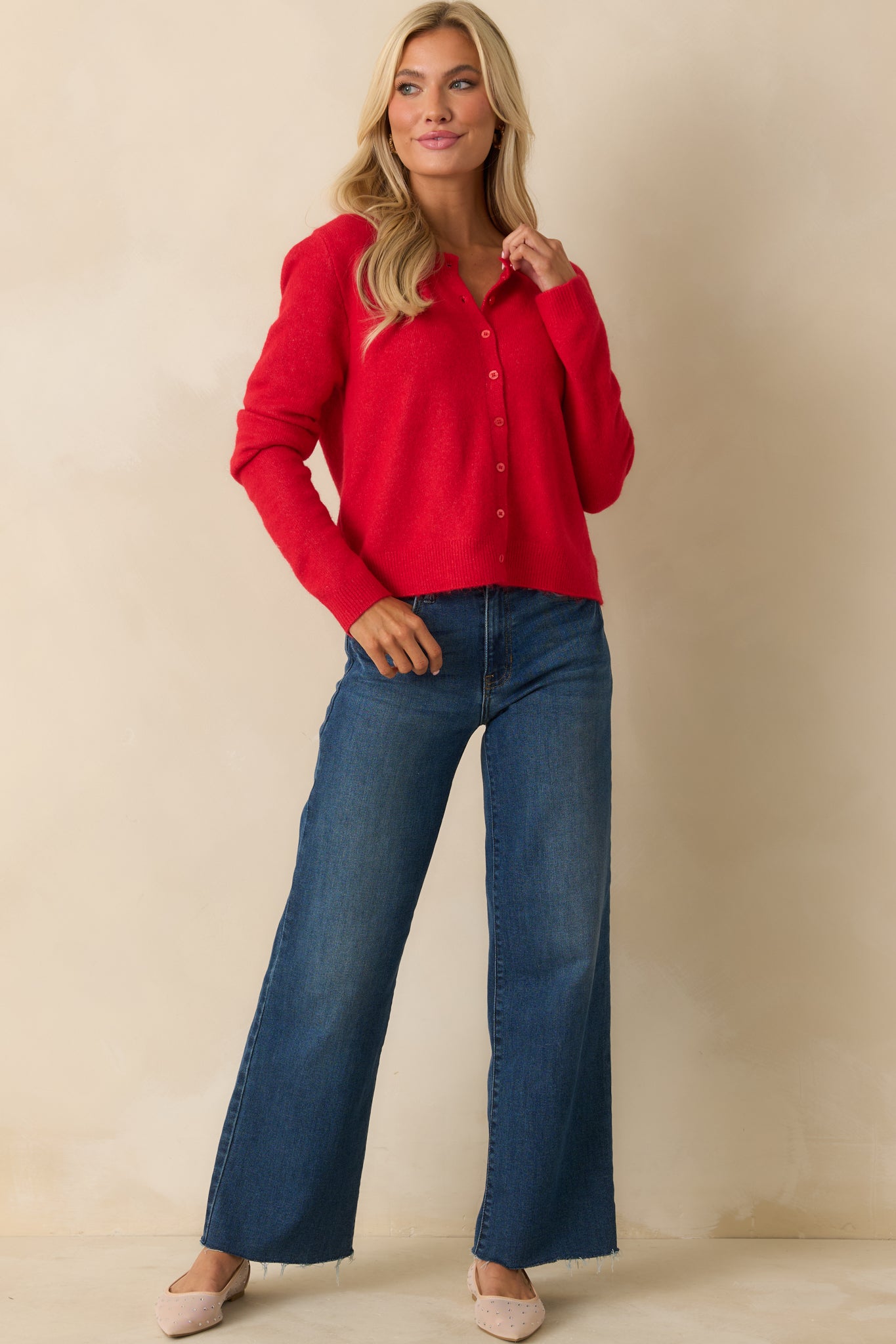 Front view of red knit cardigan featuring full button closure, long sleeves, and comfortable, easygoing silhouette.