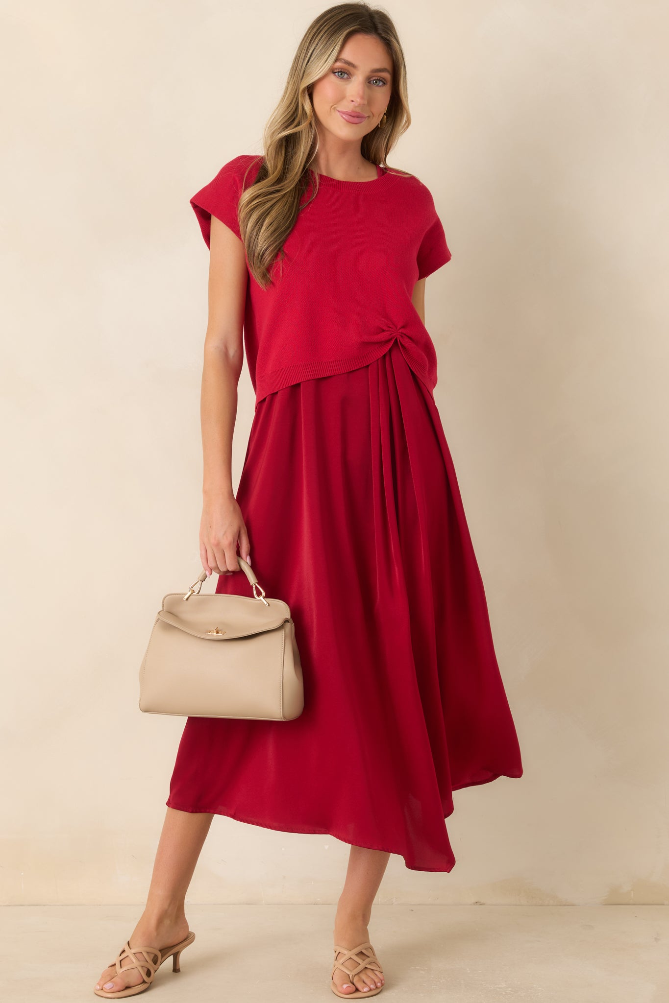 Red knit sweater featuring a relaxed silhouette, cap sleeves, and a cinched front hem detail for an effortlessly polished look.