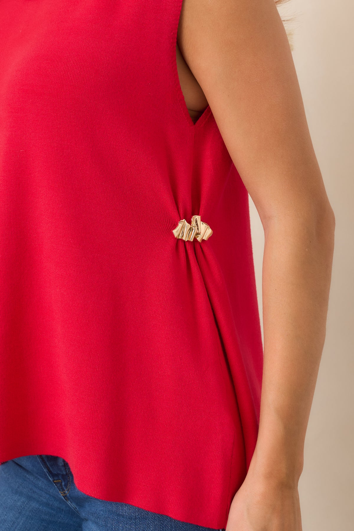 Close-up of the soft red knit fabric and gold-tone side hardware, highlighting the lightweight texture and refined detailing.