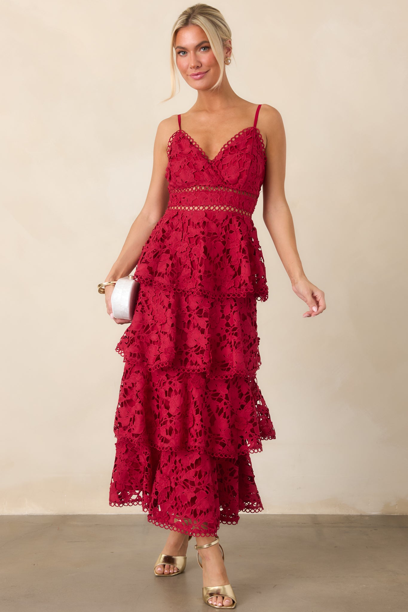 Red maxi dress featuring a V-neckline, adjustable spaghetti straps, floral lace tiered overlay, and elegant floor-length silhouette.