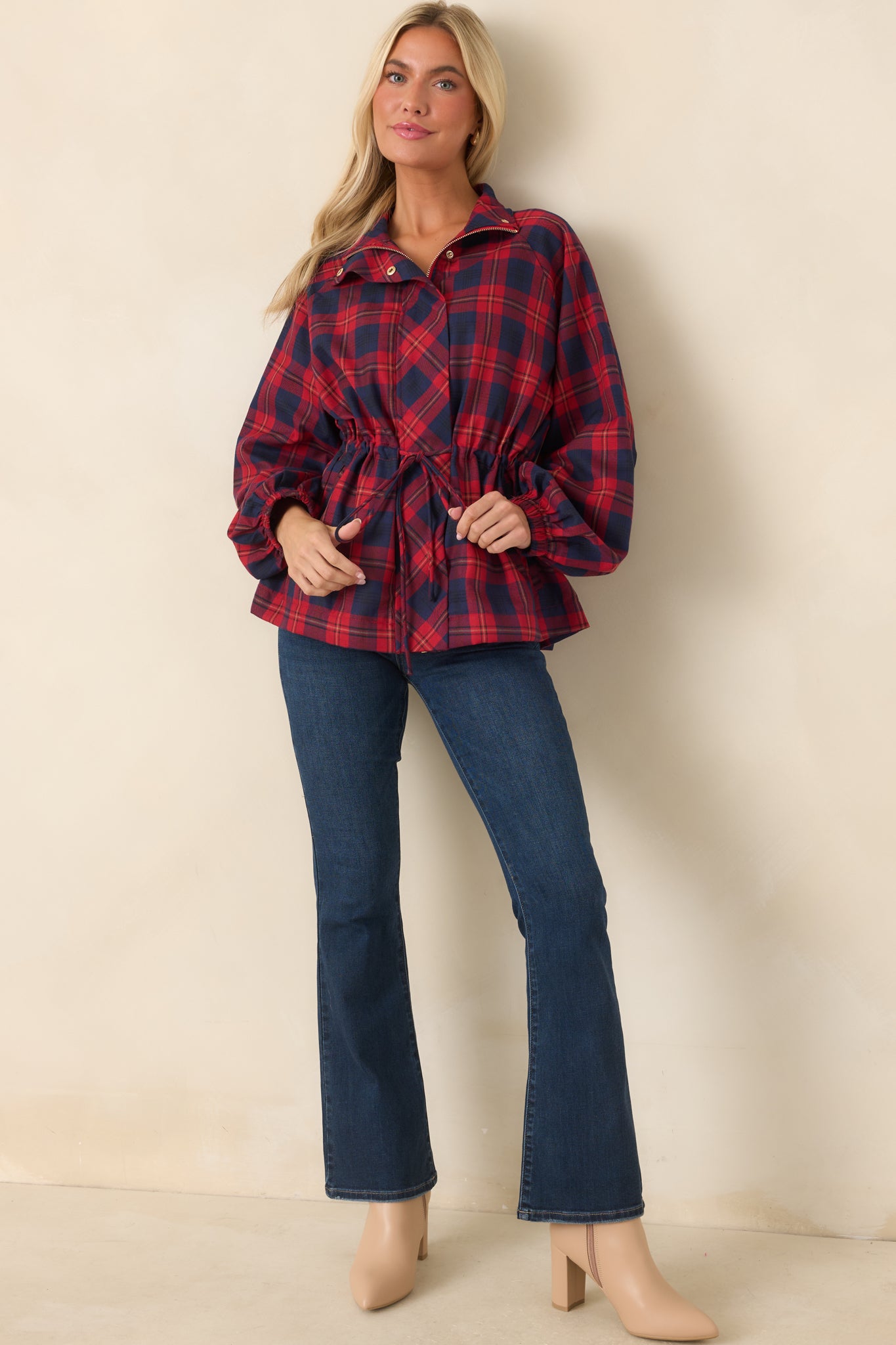 Red and navy plaid jacket showcasing long sleeves, elastic cuffs, snap accents, and a defined waist with practical front pockets.